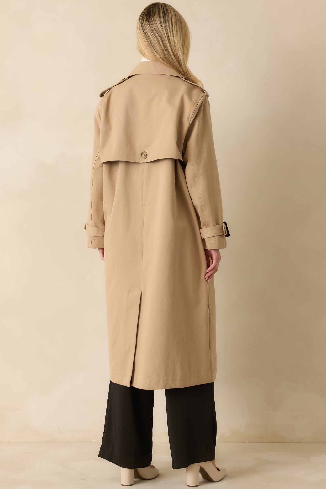Rear view of the tan trench coat showing back vent, clean lines, and mid-length silhouette.