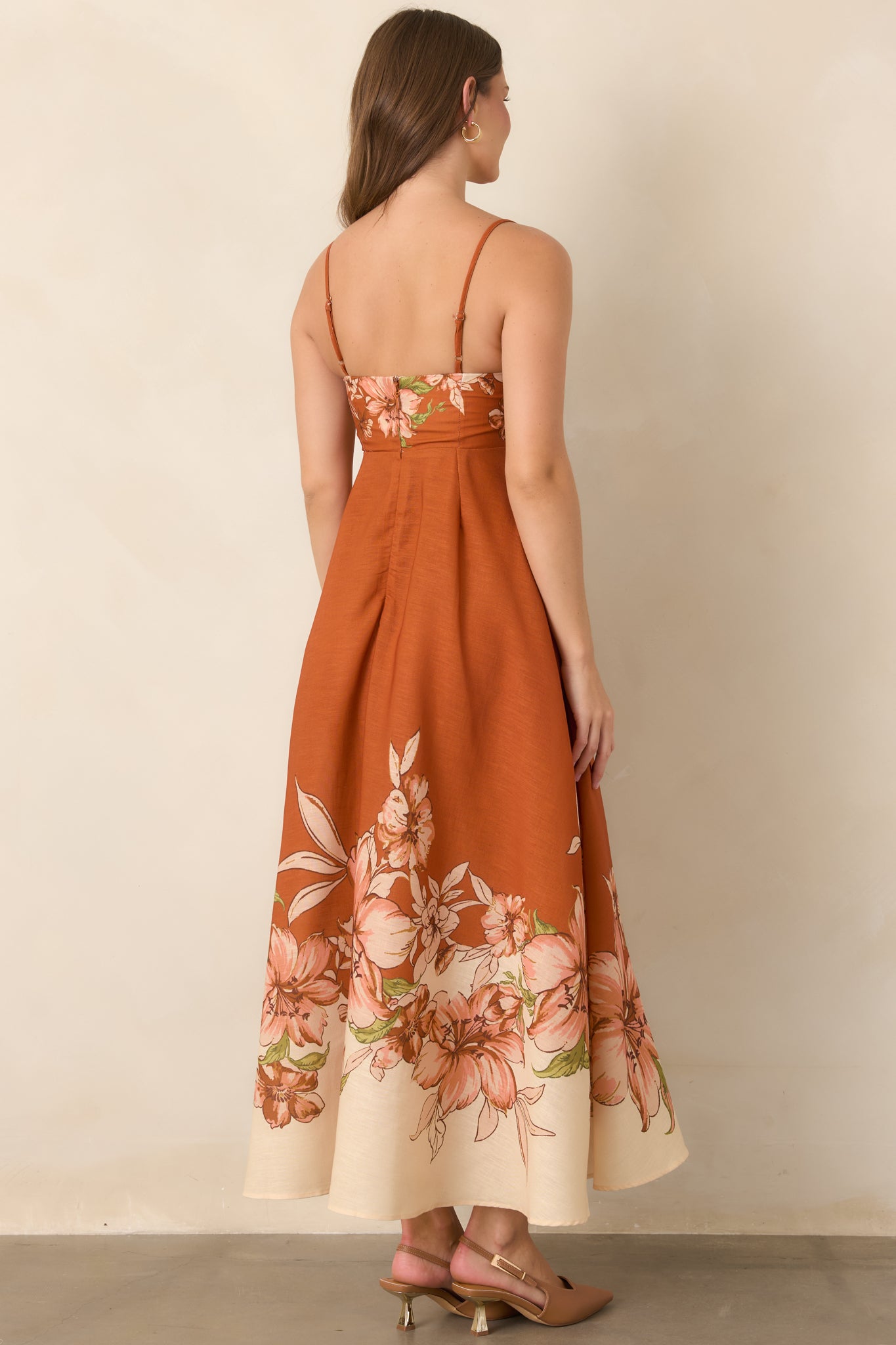 Rear view of the terracotta floral dress featuring slim adjustable straps and a softly flowing empire-waist skirt.