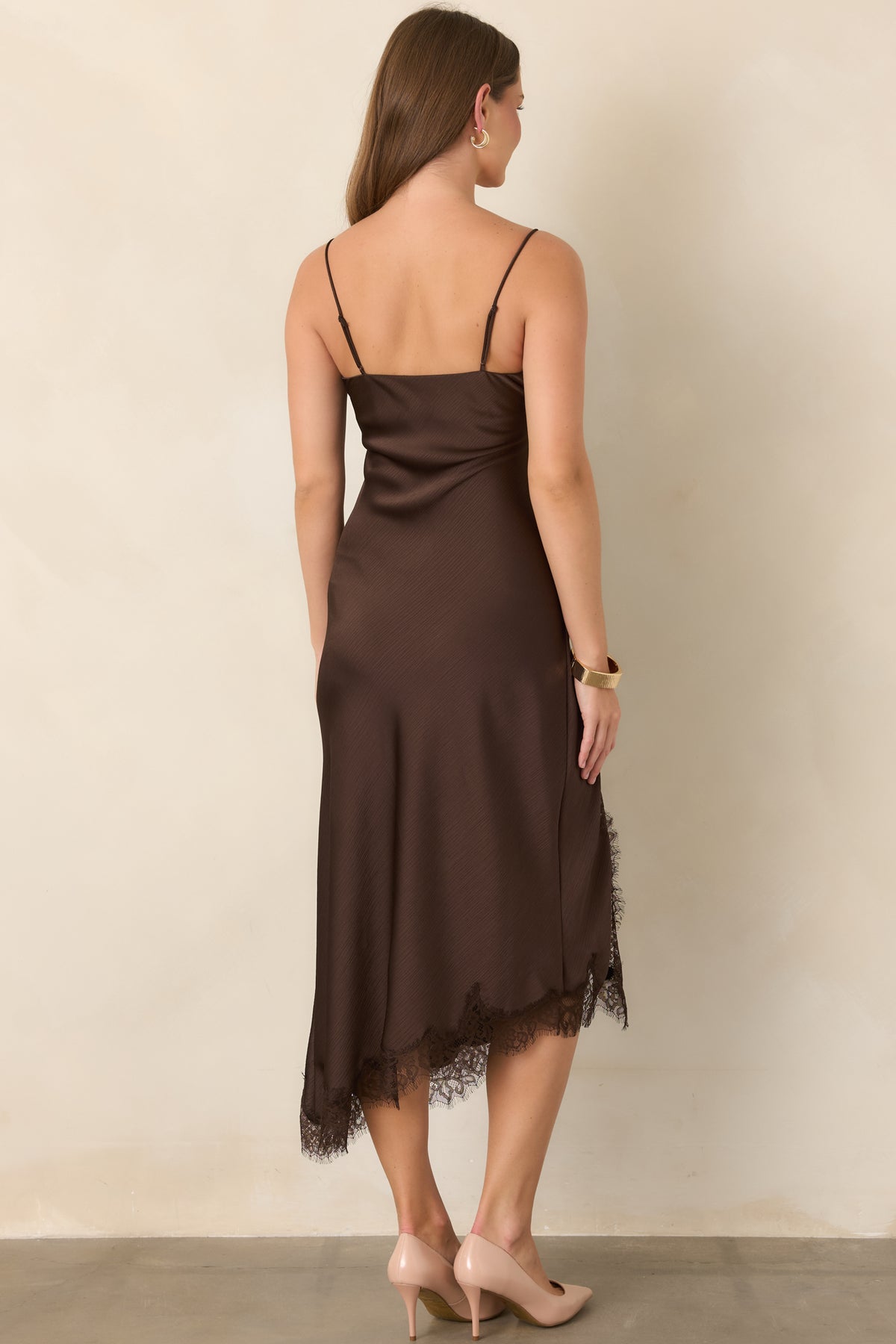 Rear view of the textured satin midi dress showcasing the adjustable spaghetti straps, smooth bias-cut silhouette, and asymmetrical lace-trimmed hem.