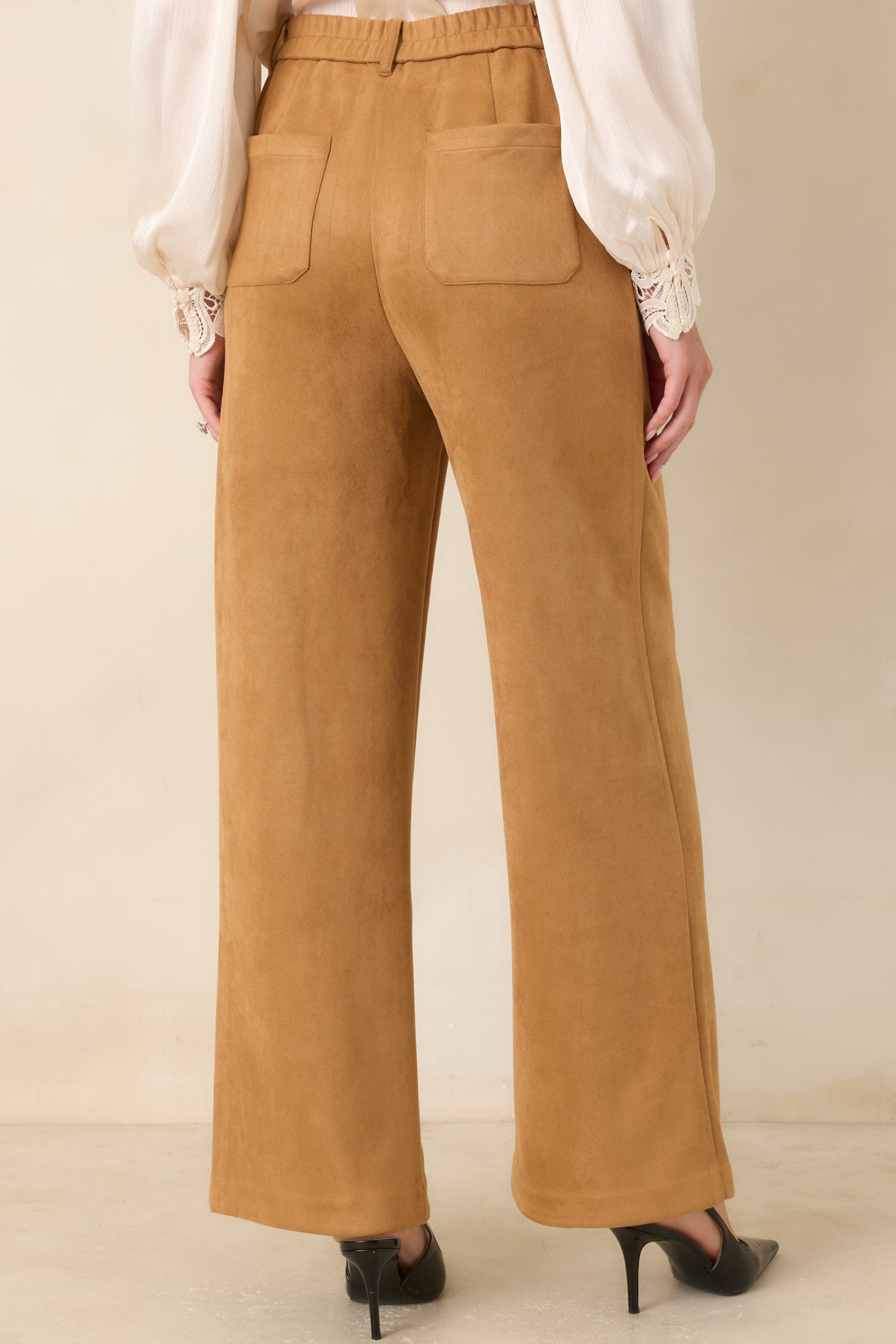 Rear view of the wide-leg pants featuring the elasticized back waistband, back patch pockets, and full-length tailored silhouette.