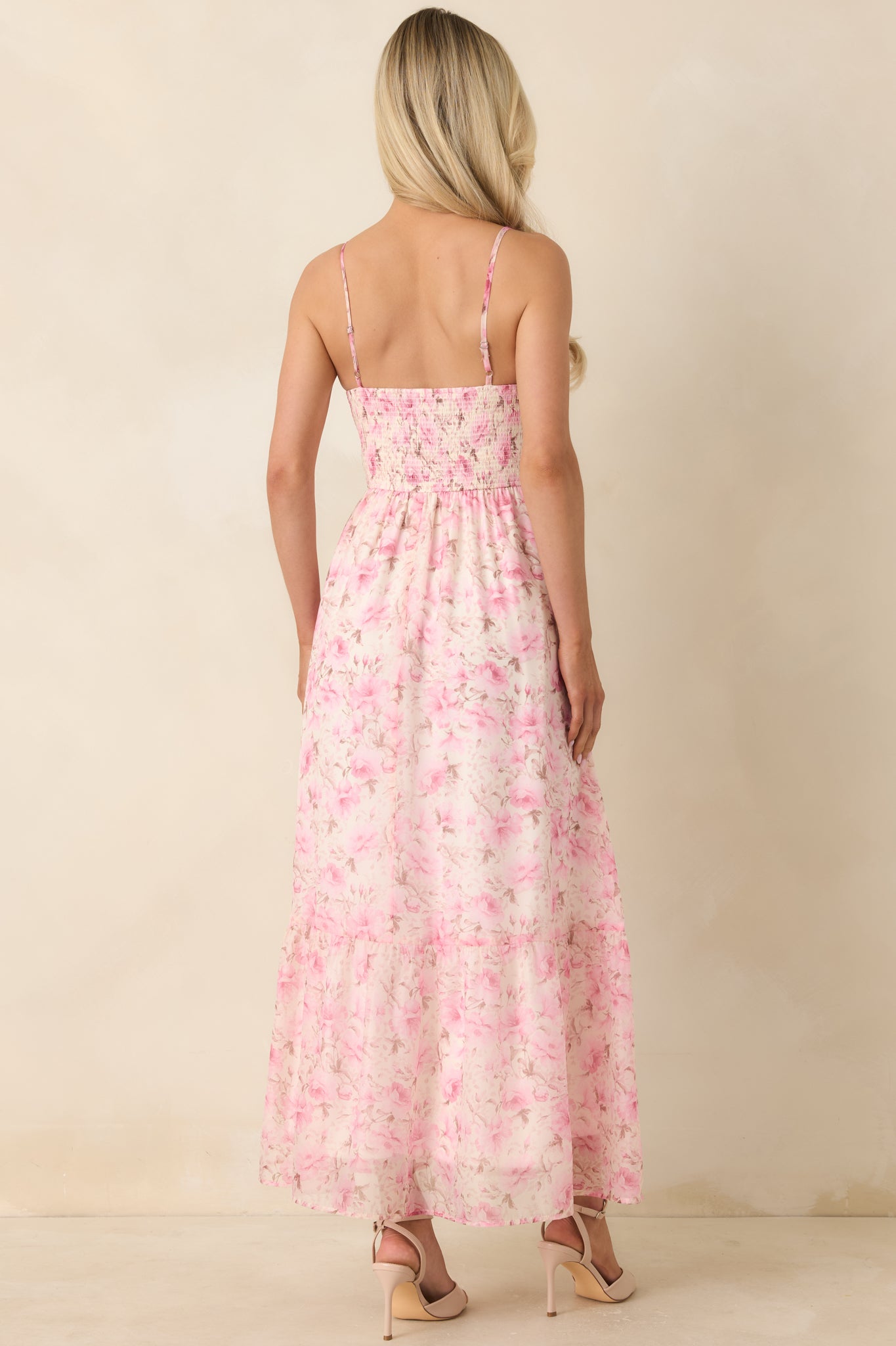 Rear view of pink multi floral midi dress with adjustable spaghetti straps and flowing silhouette.