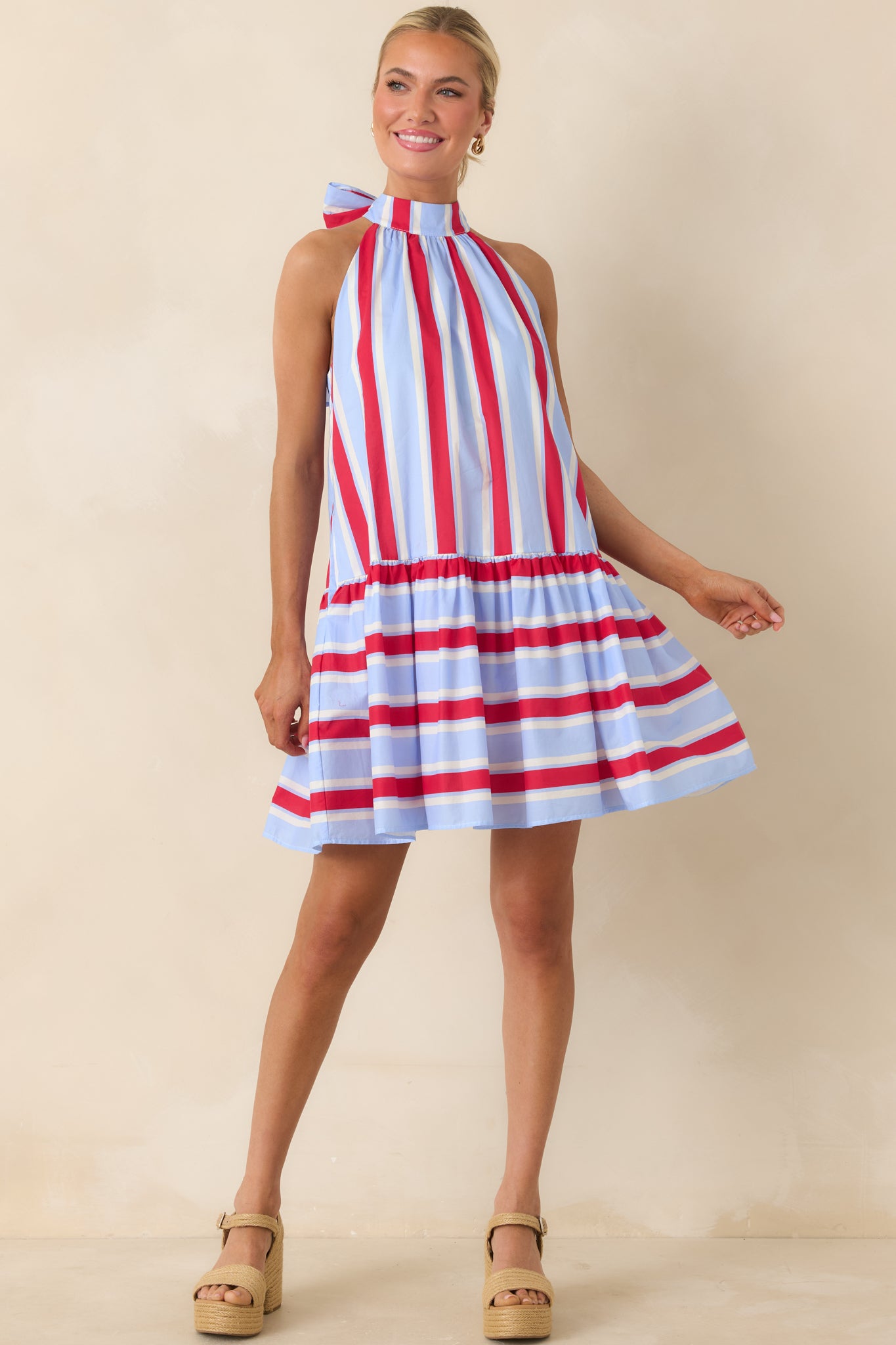 Red-and-blue striped dress with gathered skirt and subtle back keyhole tie detail.