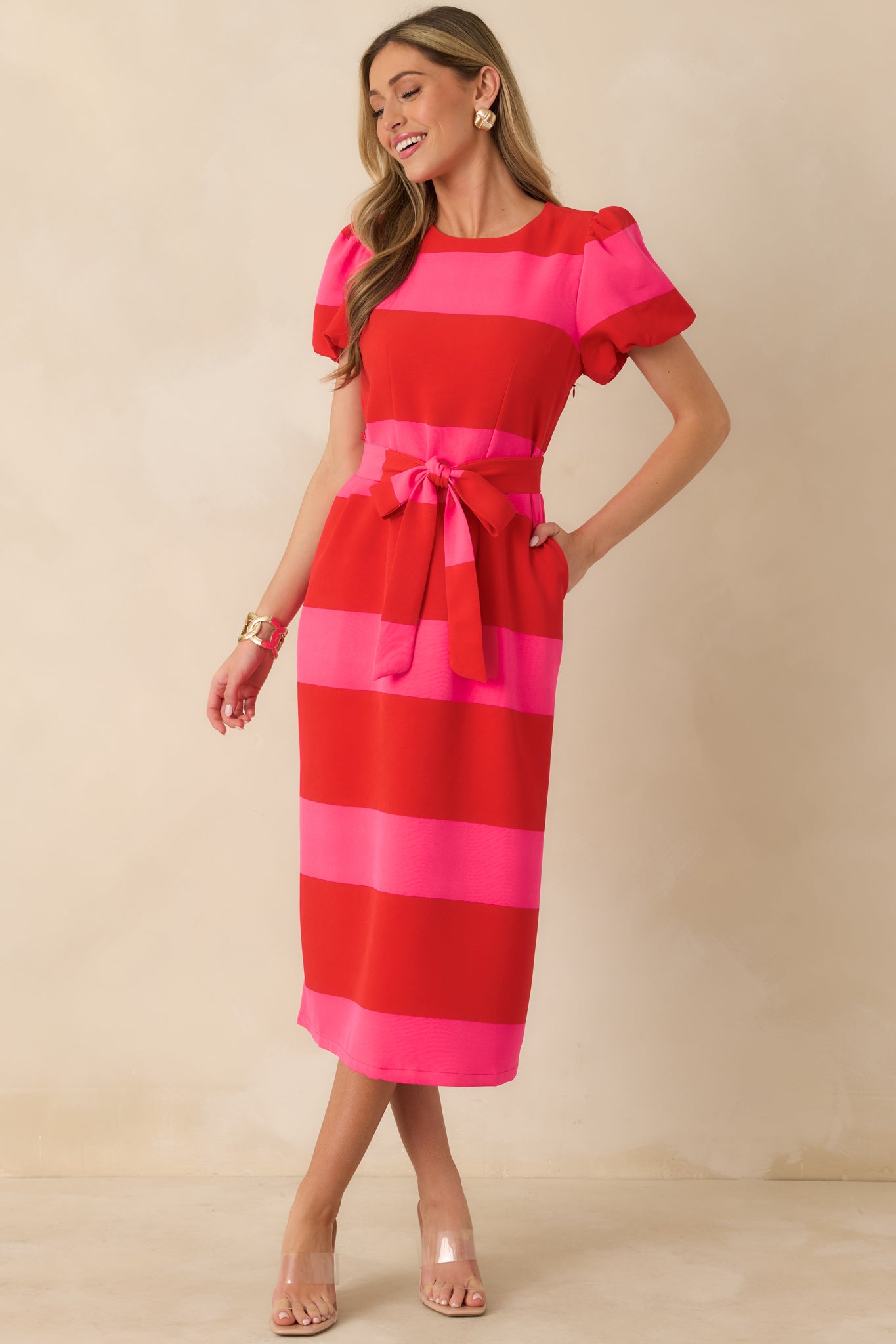 Red and pink striped dress with short puff sleeves and fully lined construction for comfortable wear.
