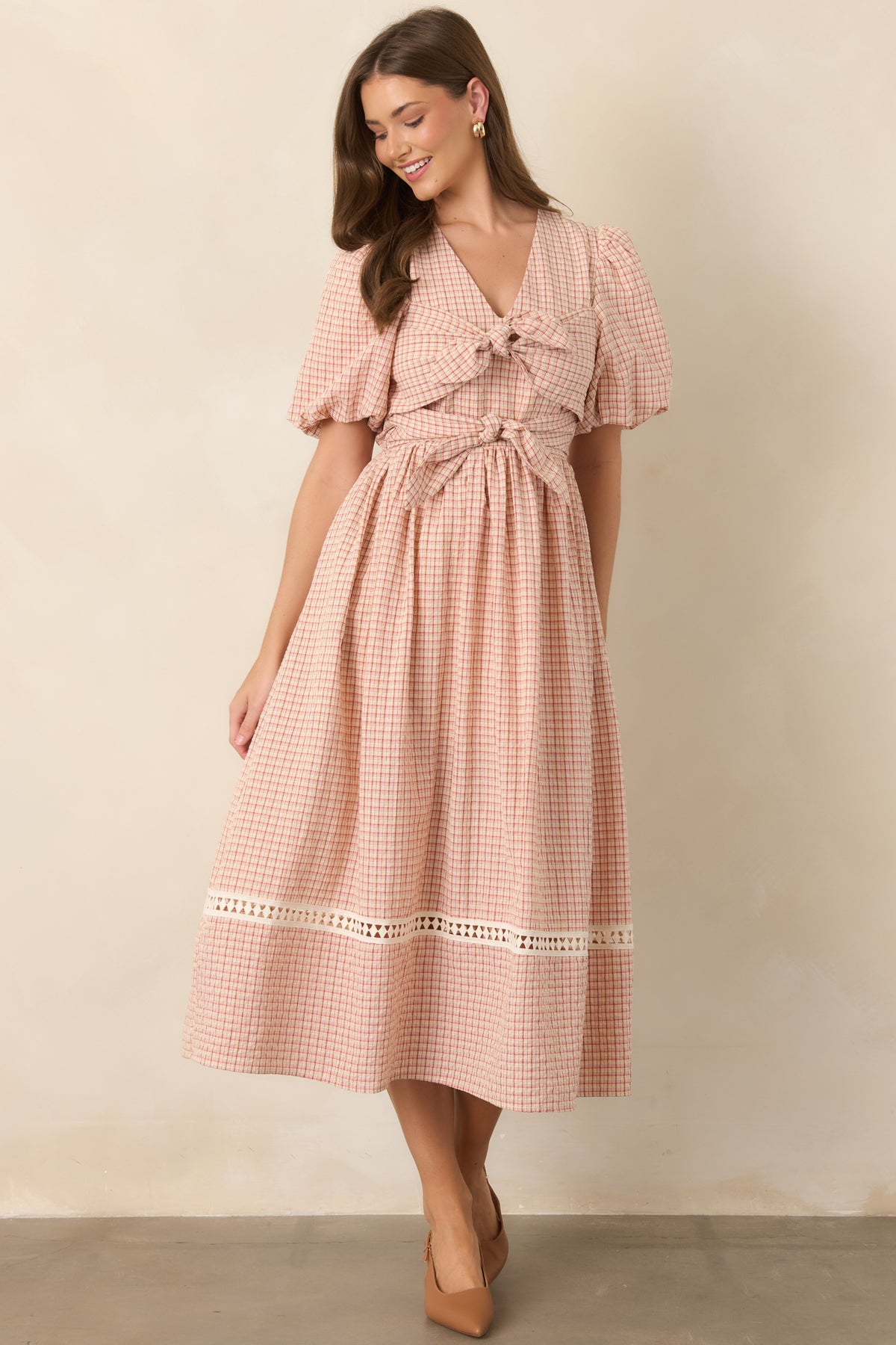 Playful red and beige plaid midi dress featuring a structured bodice, puff sleeves, double front ties, and a flowing skirt.