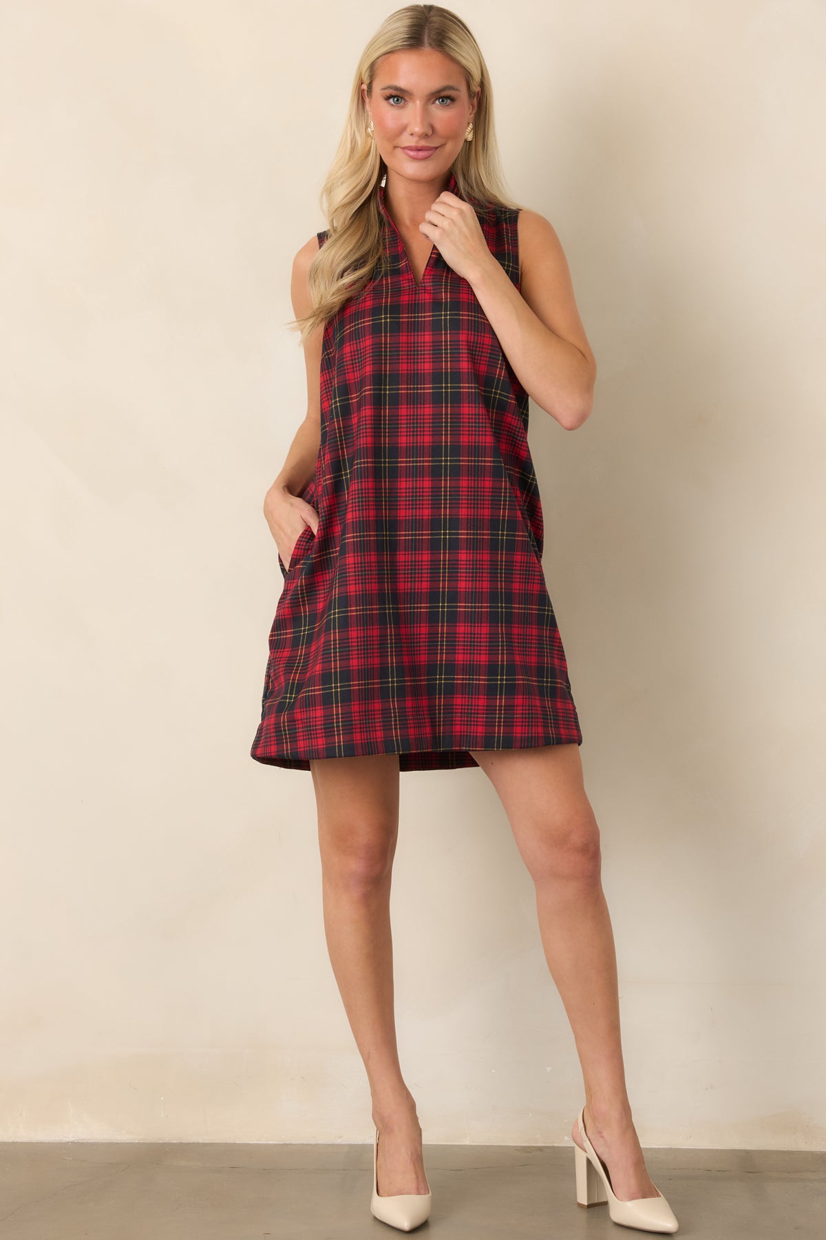 Relaxed plaid mini dress featuring fine contrasting lines, a structured neckline, sleeveless construction, and side pockets.