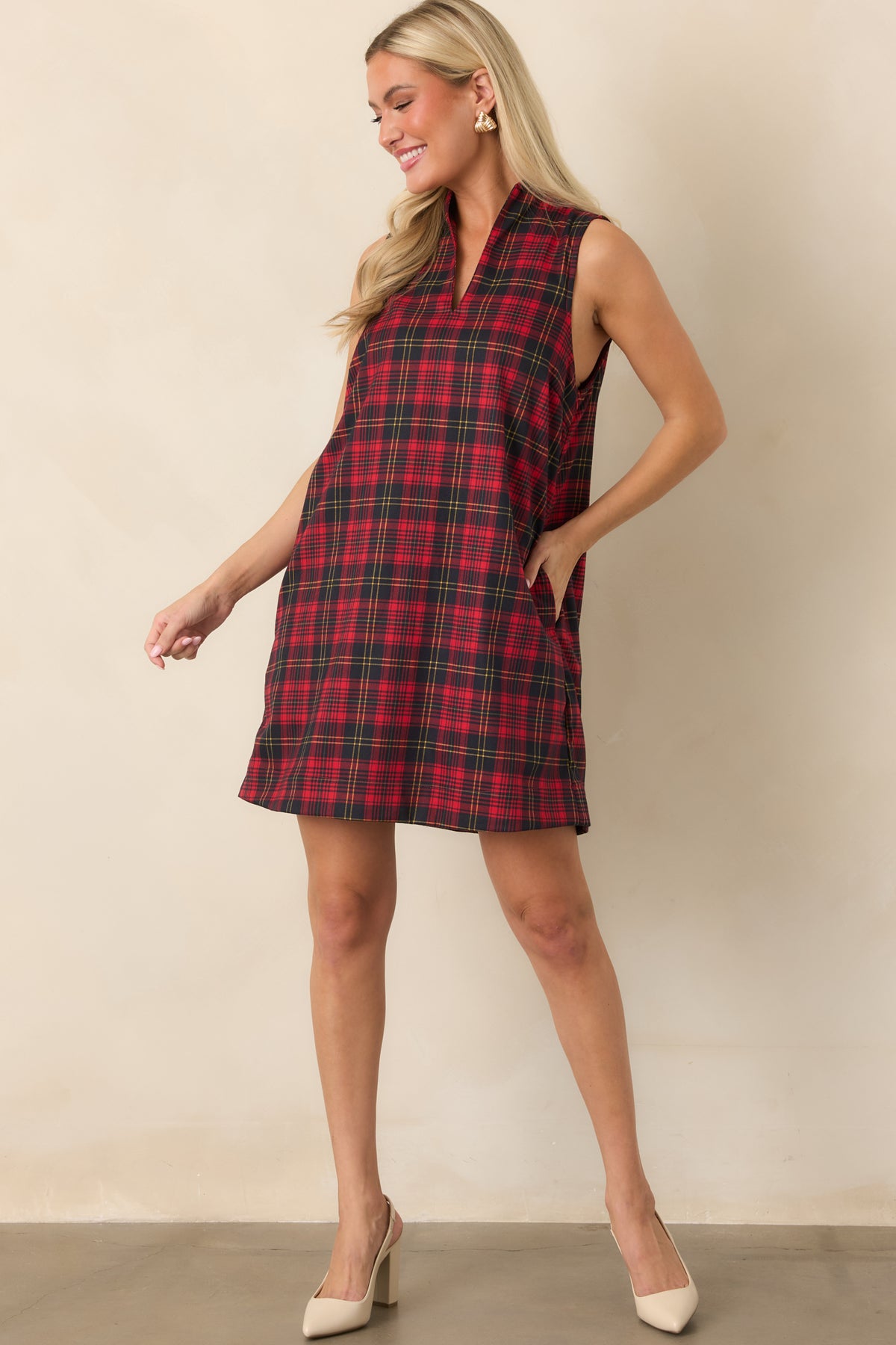 Red and black plaid shift dress with a standing neckline, split front, and easy sleeveless silhouette.