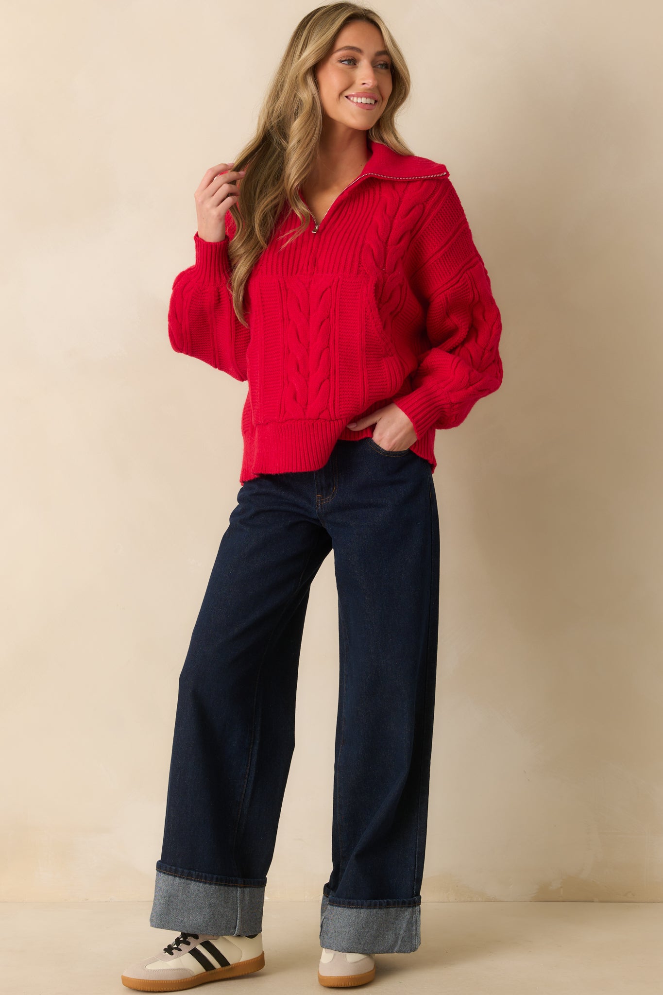 Red cable knit sweater with a fold-over collar and quarter zip closure.