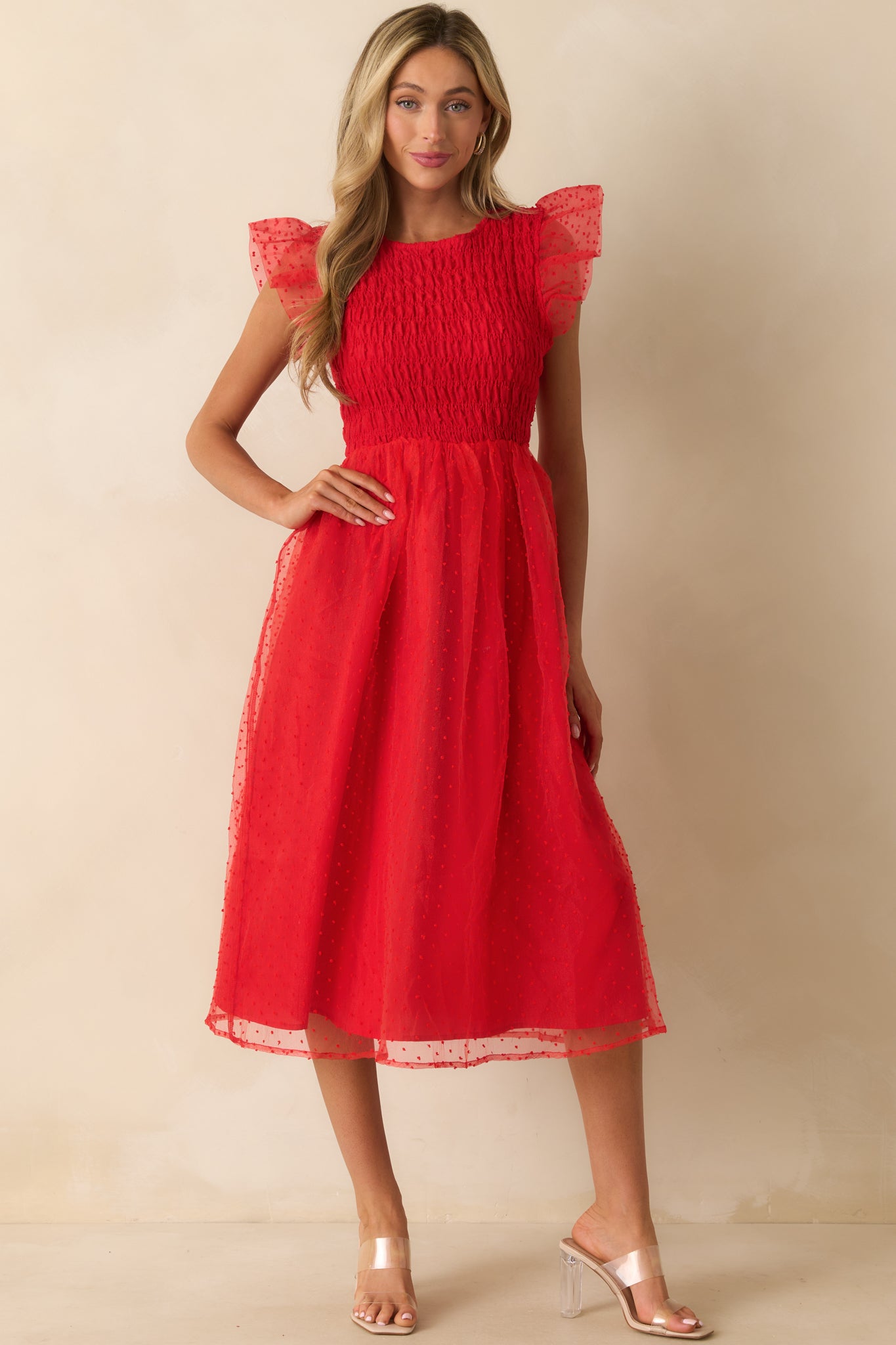 Red dress showing the flutter sleeves and sheer tulle detail.