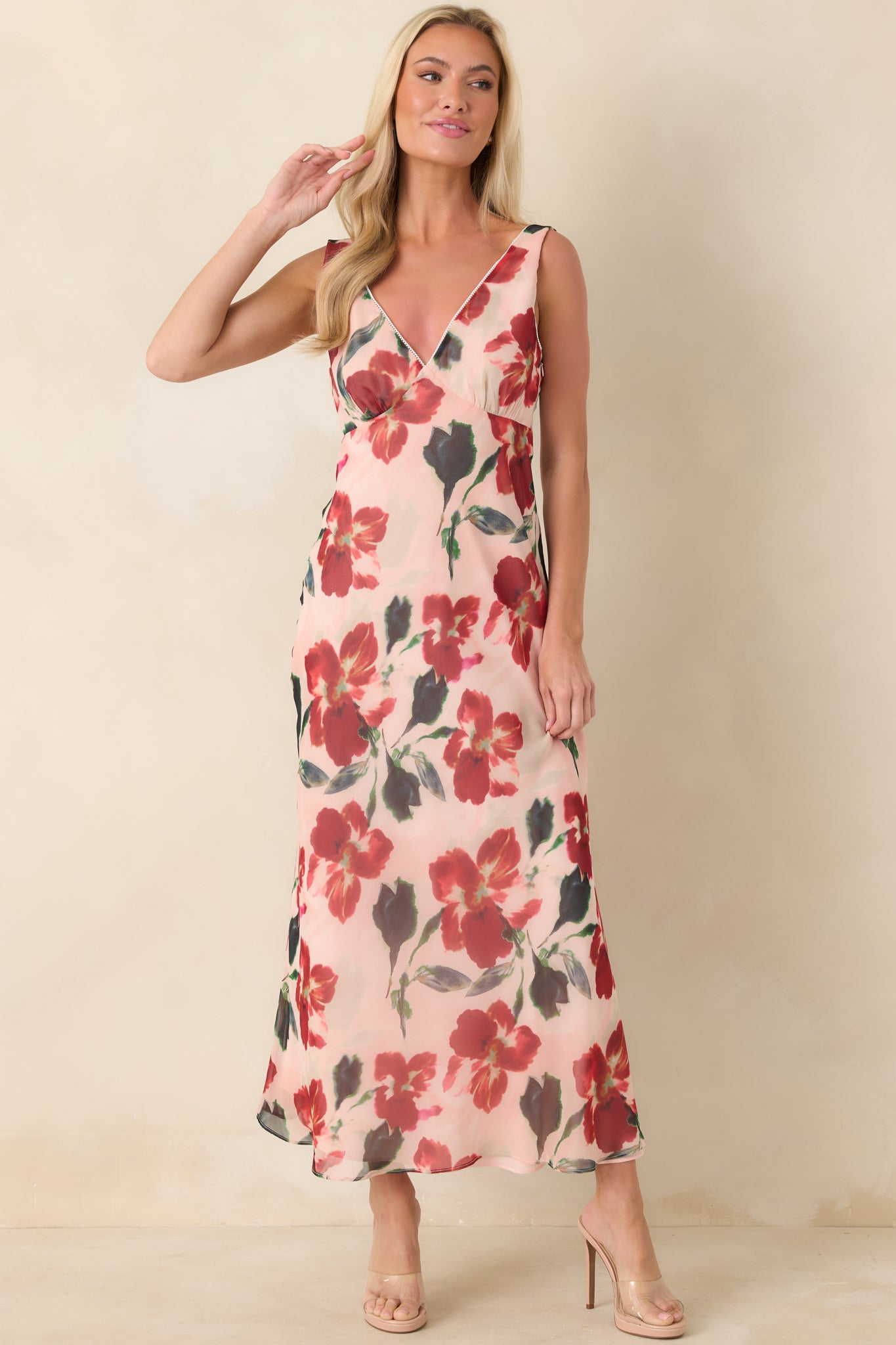 Full-length front shot of red floral dress highlighting fitted bodice and elongated midi-length silhouette.