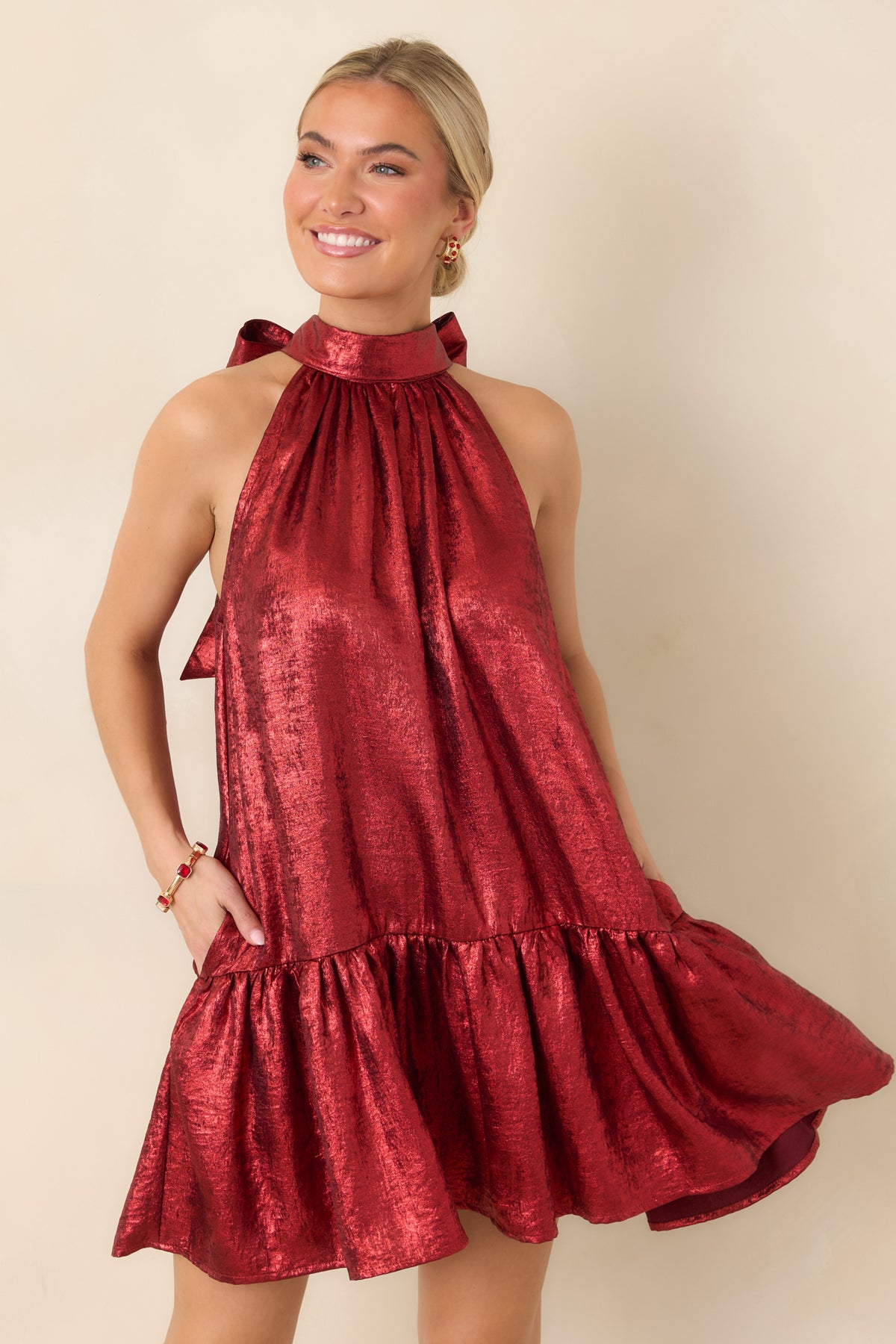Red mini dress highlighting the gathered halter neckline and softly draped fabric across the bodice.