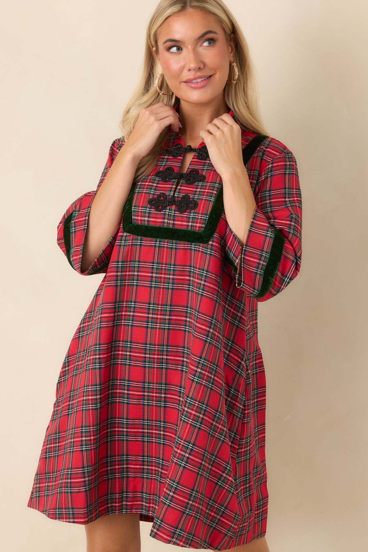 Red and green plaid fabric paired with dark green velvet trim along the three-quarter sleeves and front panel.