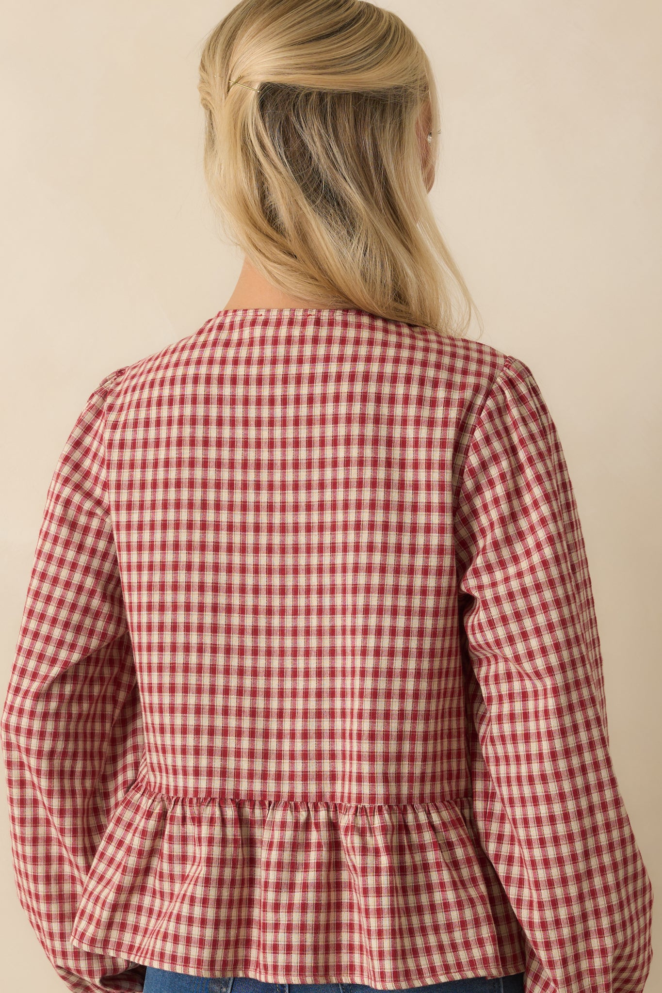 Back view of red and ivory gingham top with balloon sleeves and peplum silhouette.