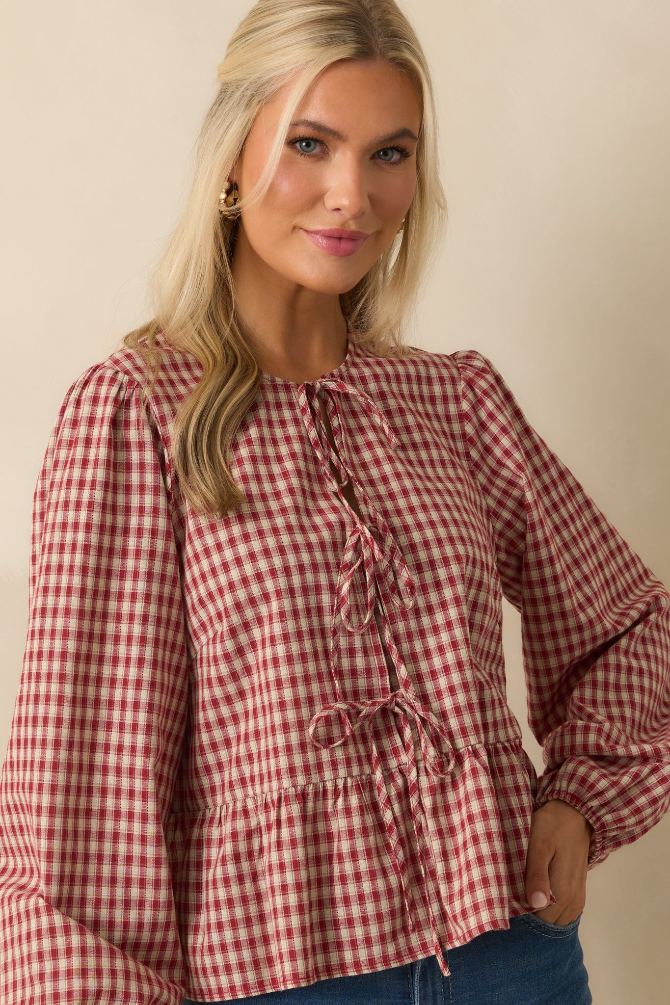 Torso view of red and ivory gingham top with sewn-in panel under second bow.