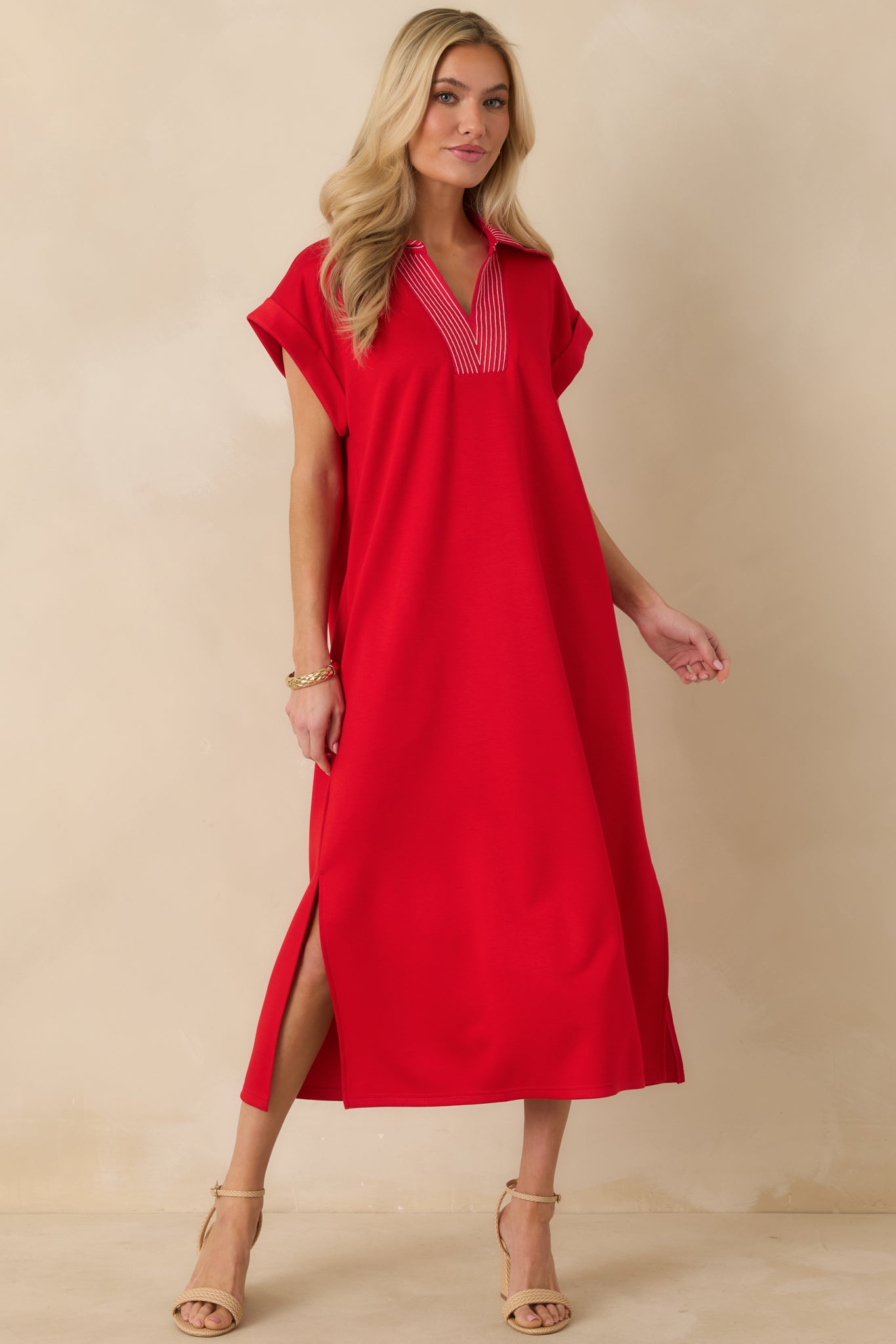 Red knit midi dress designed with contrast stitching at the V-neck and a midi-length hem.