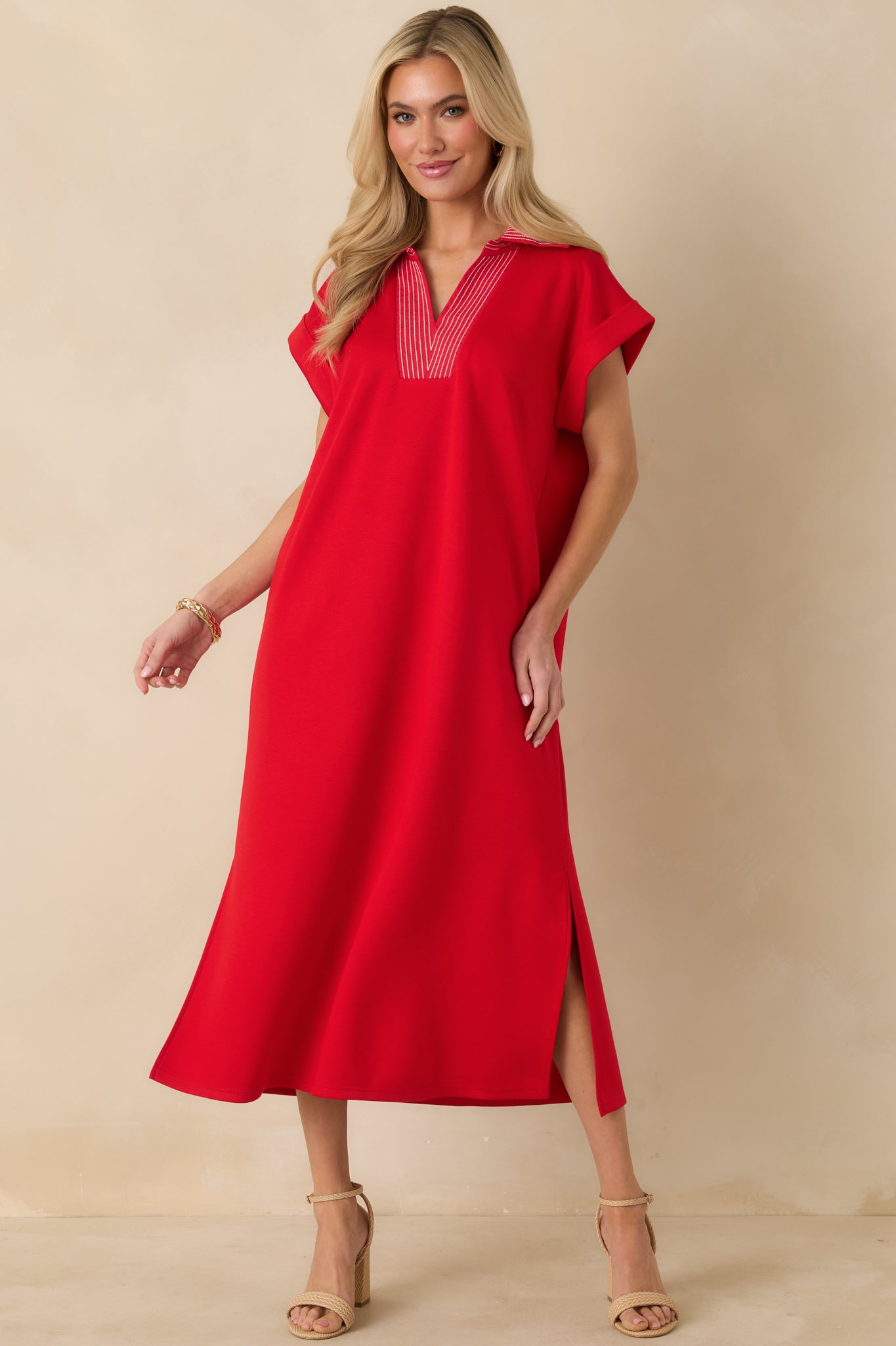 Red knit midi dress showing a relaxed shape, short sleeves, and subtle side slits.