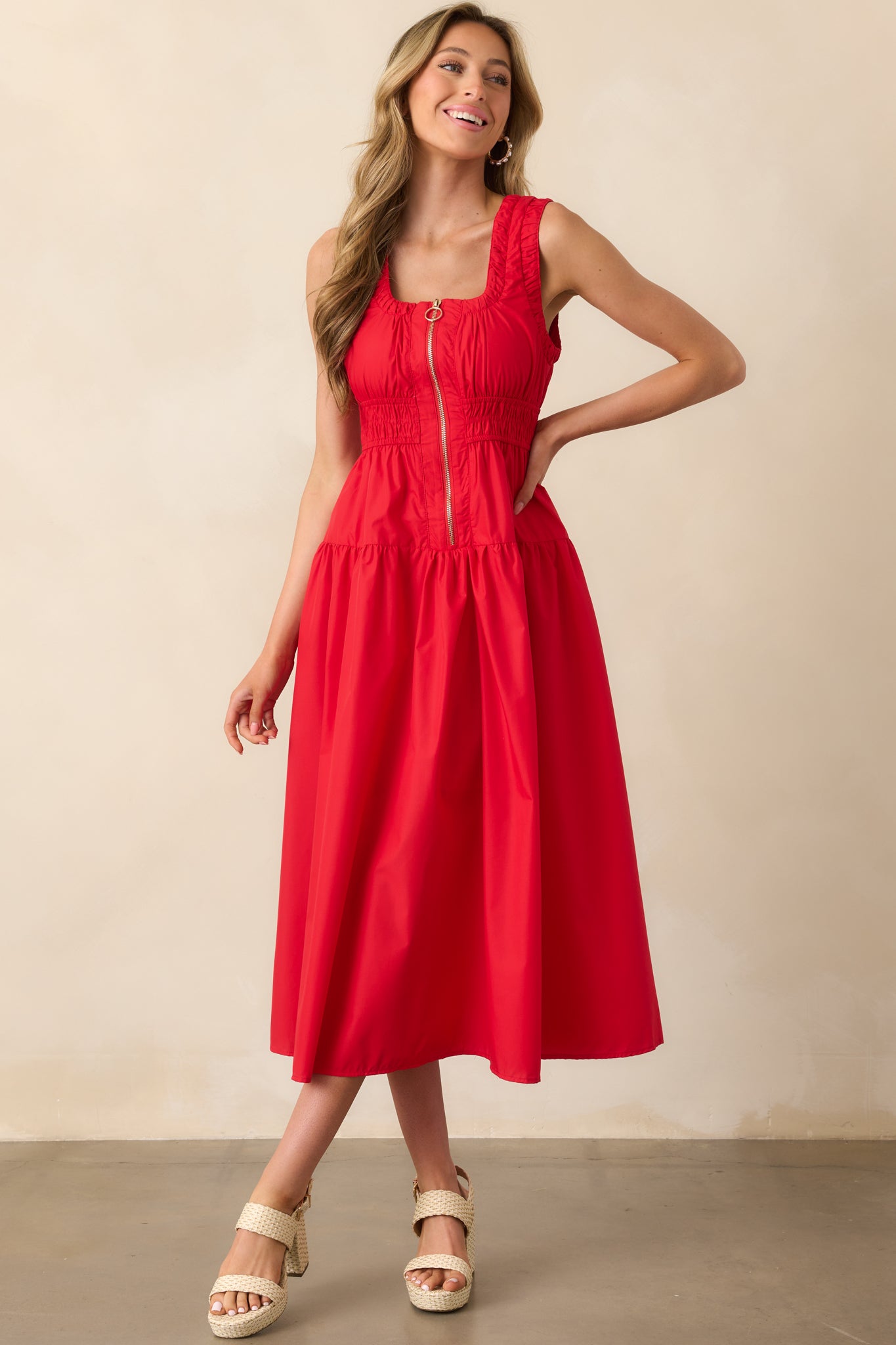Front view of a red midi dress with a scoop neckline, sleeveless cut, and o-ring zip front closure.