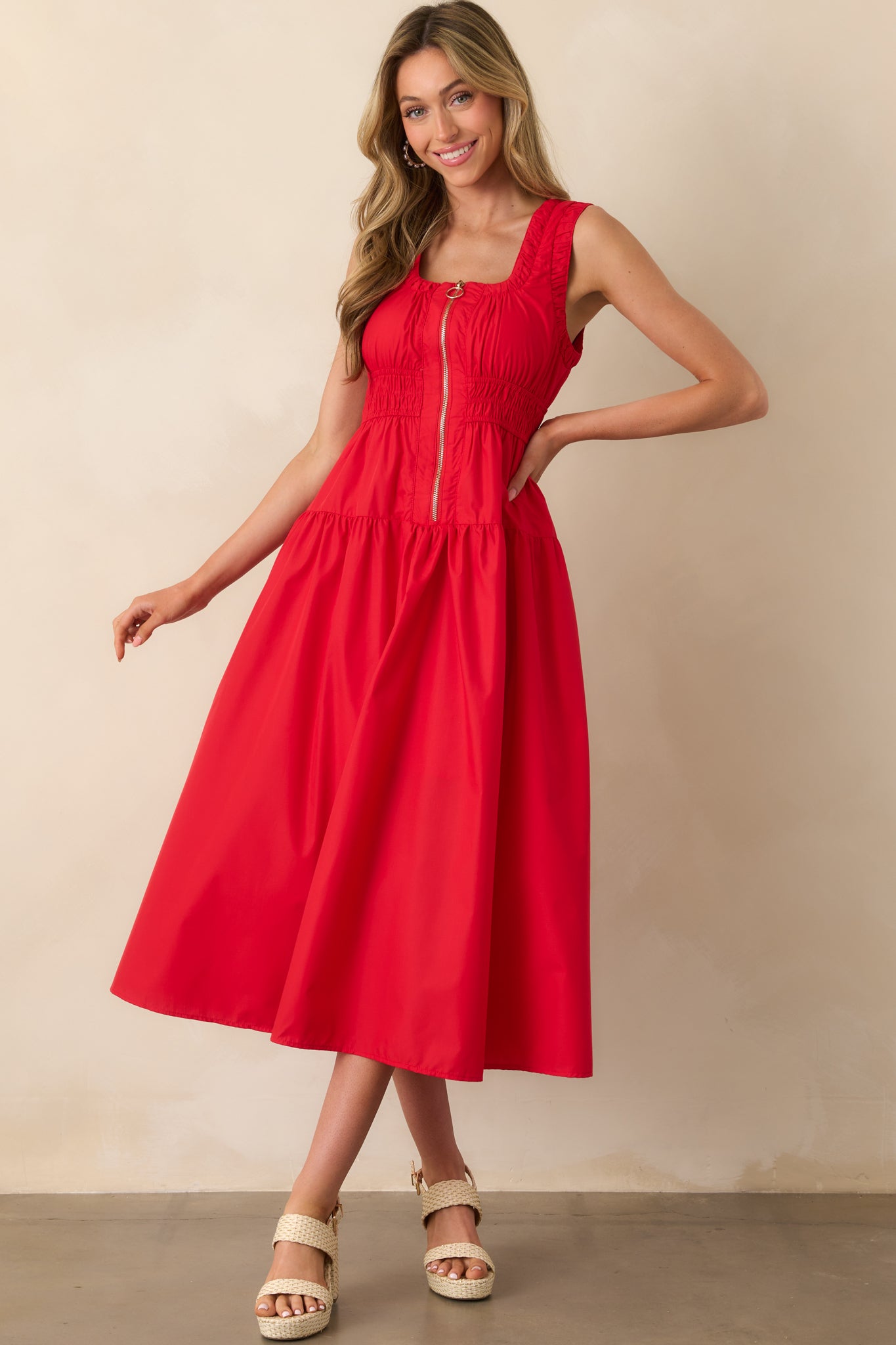 Red sleeveless midi dress shown in full length, highlighting the ruched elastic waist and functional front zipper.