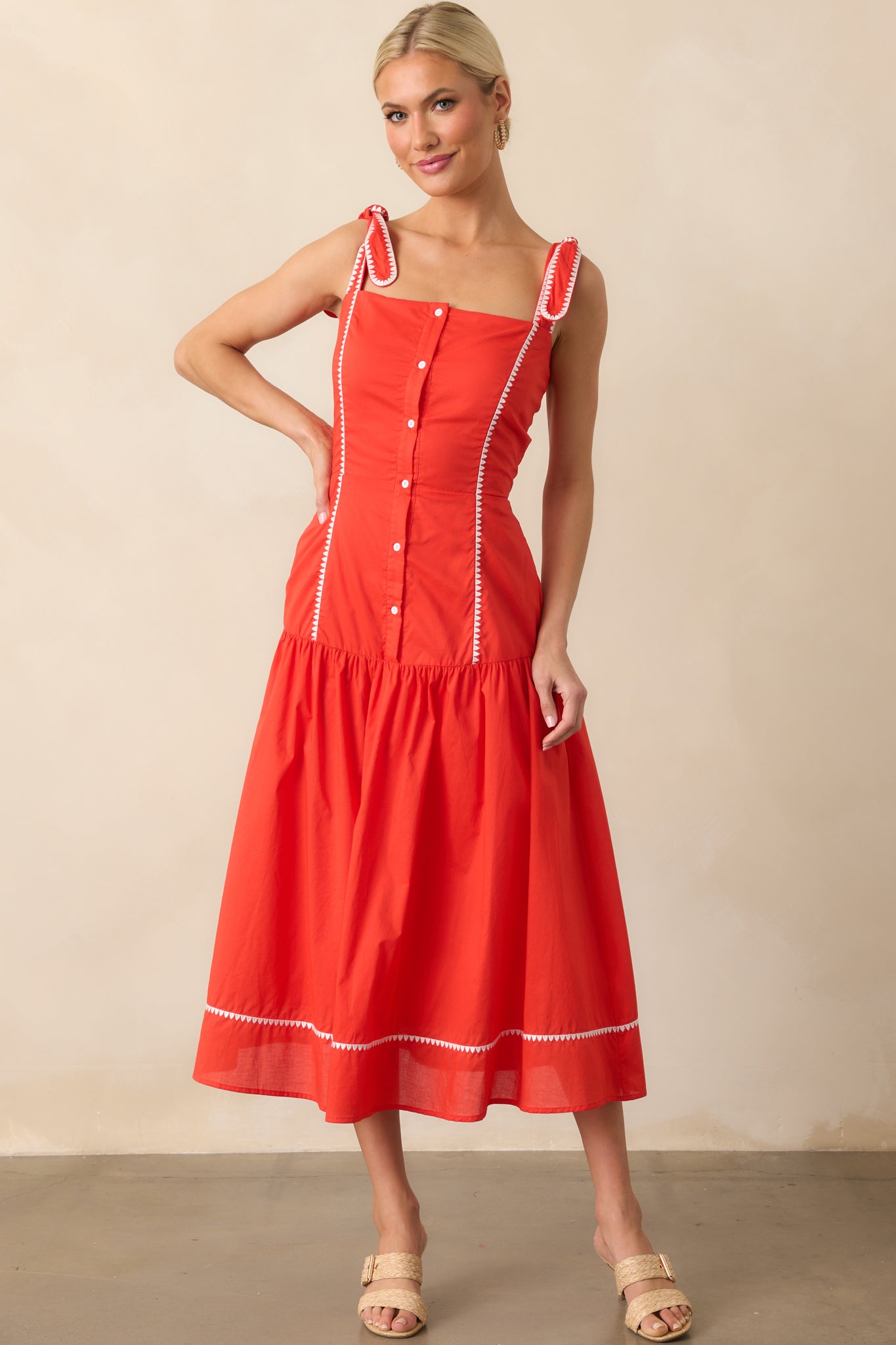 Front view of the tomato red midi dress showing the square neckline, self-tie shoulder straps, and button front design.