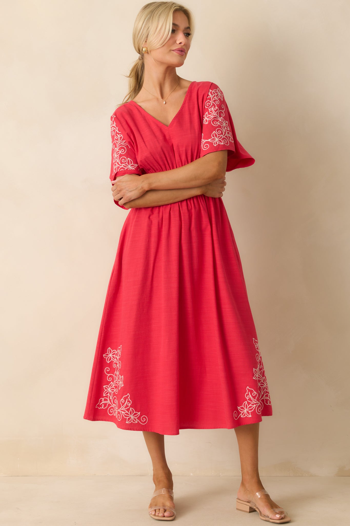Red midi dress with ivory floral embroidery and a v-neckline.