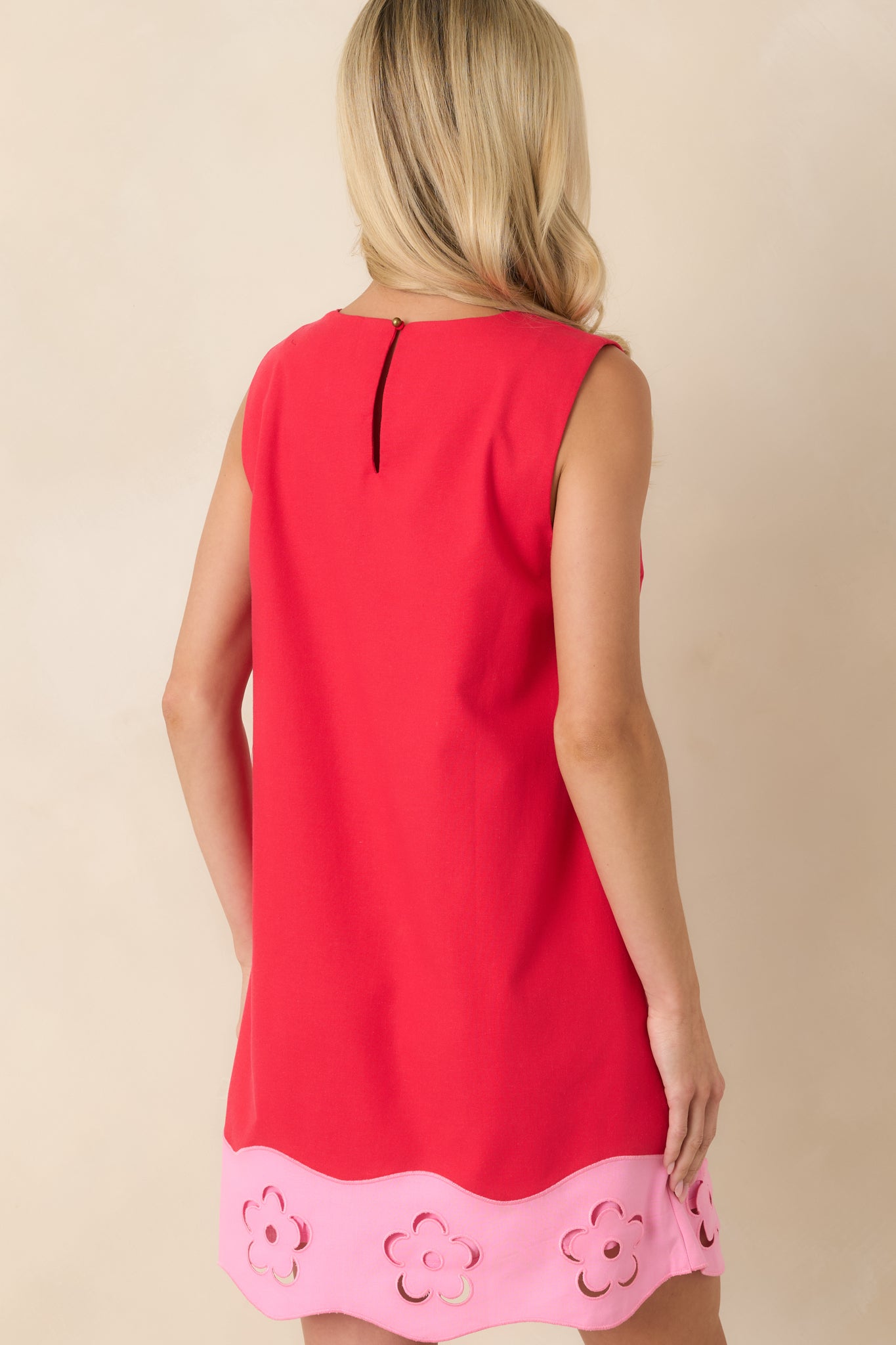 Back view of the red mini dress featuring a keyhole opening with button closure and relaxed silhouette.