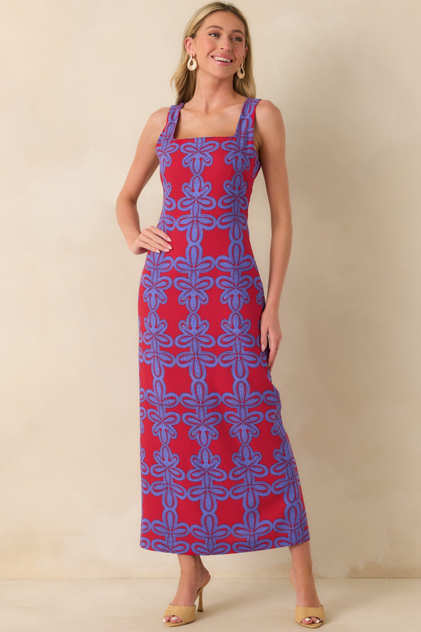 A front view of the maxi dress showing the bright red and light indigo geometric print and square neckline.