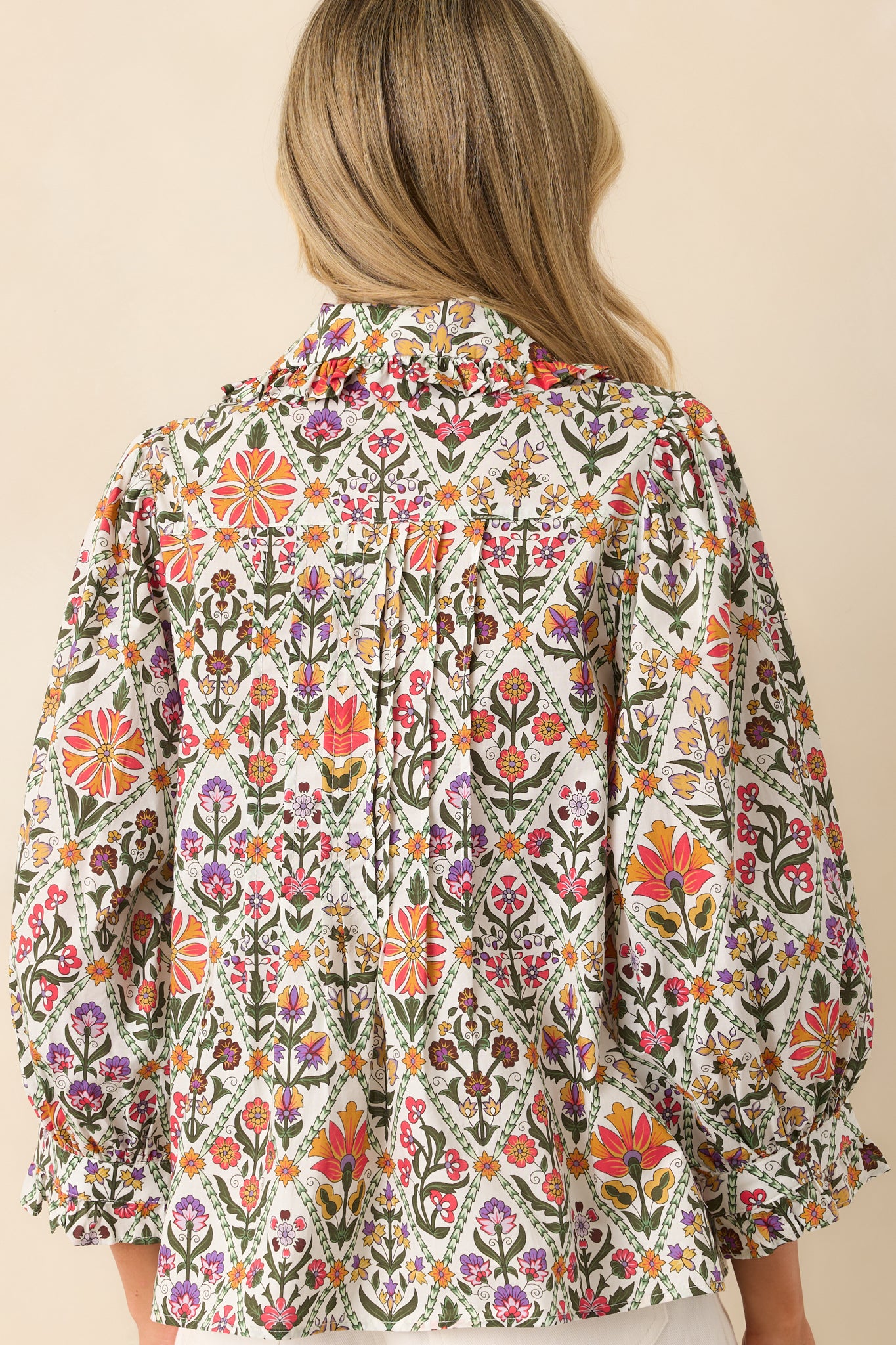 A view from behind showing the full print, relaxed fit, and ruffle collar extending around the neckline.