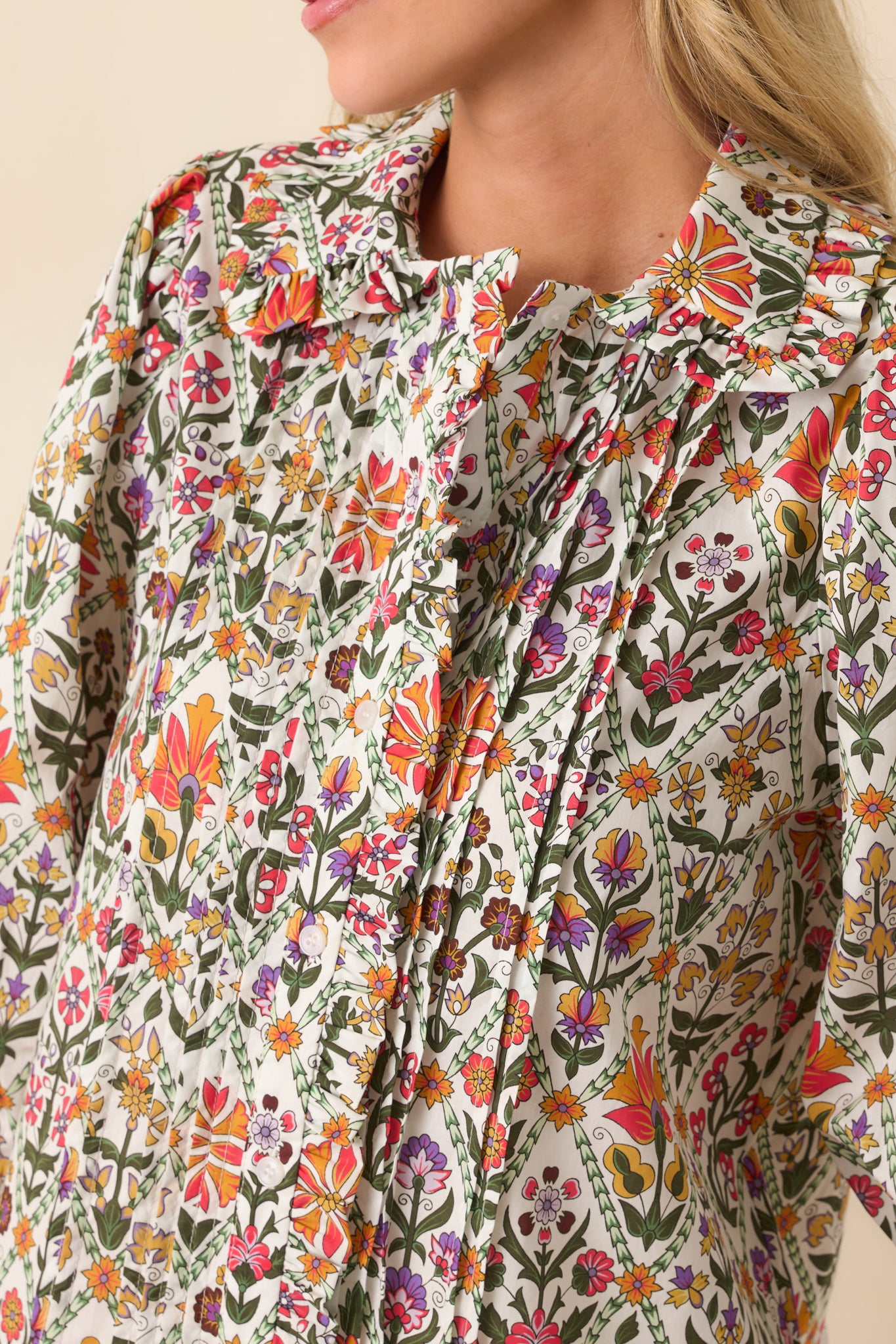 Zoomed-in image capturing the pintuck detailing, ruffle edges, and button texture.