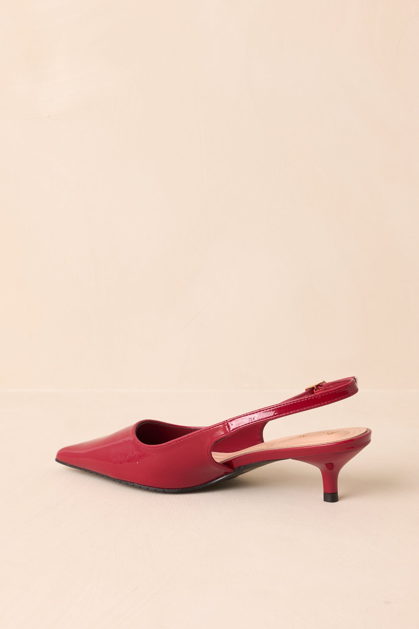 Rear view of the red patent slingback heels highlighting the slim heel and back strap.