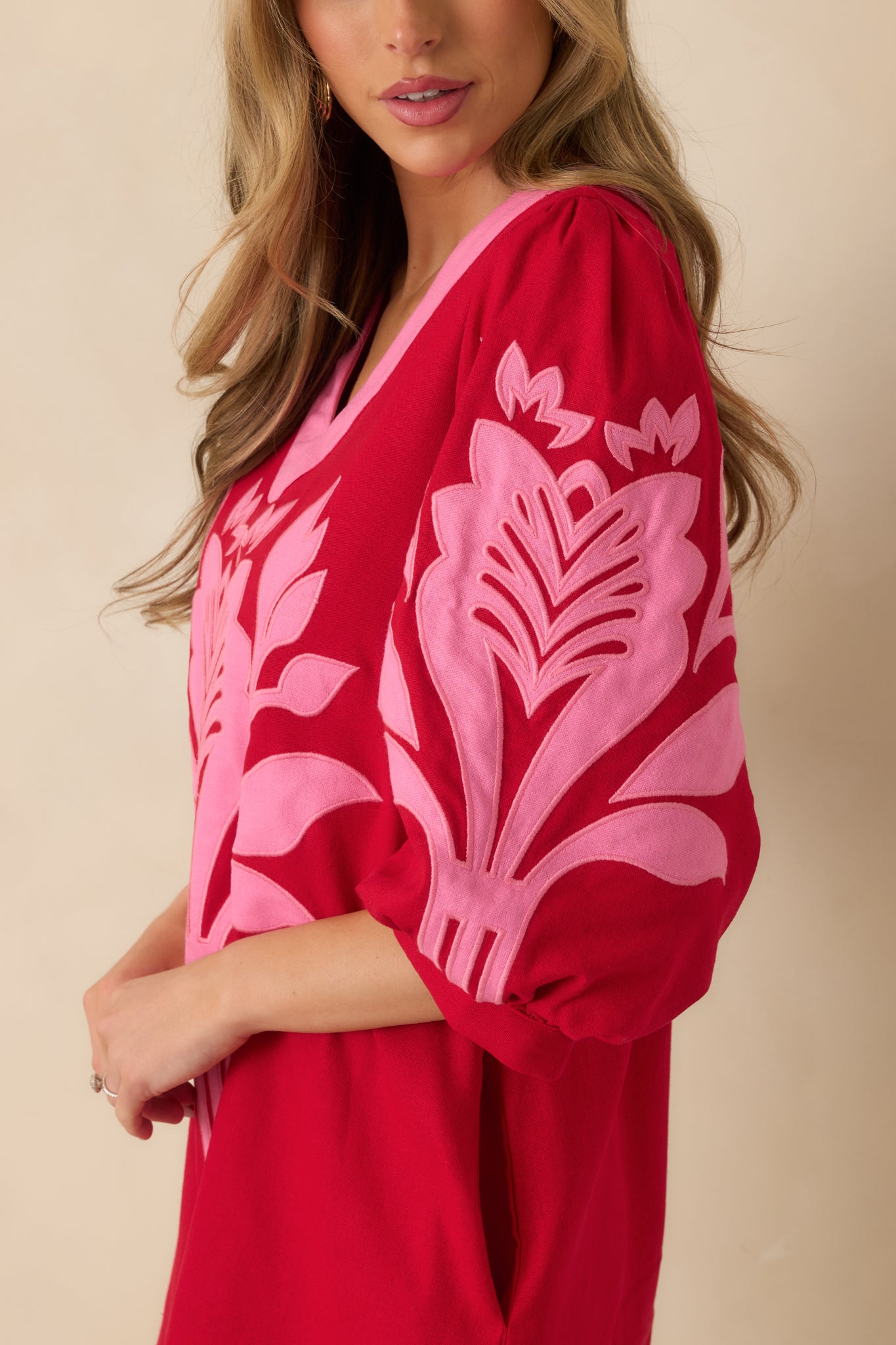 Cropped detail of the short puff sleeves and gathered cuffs on the red and pink mini dress.