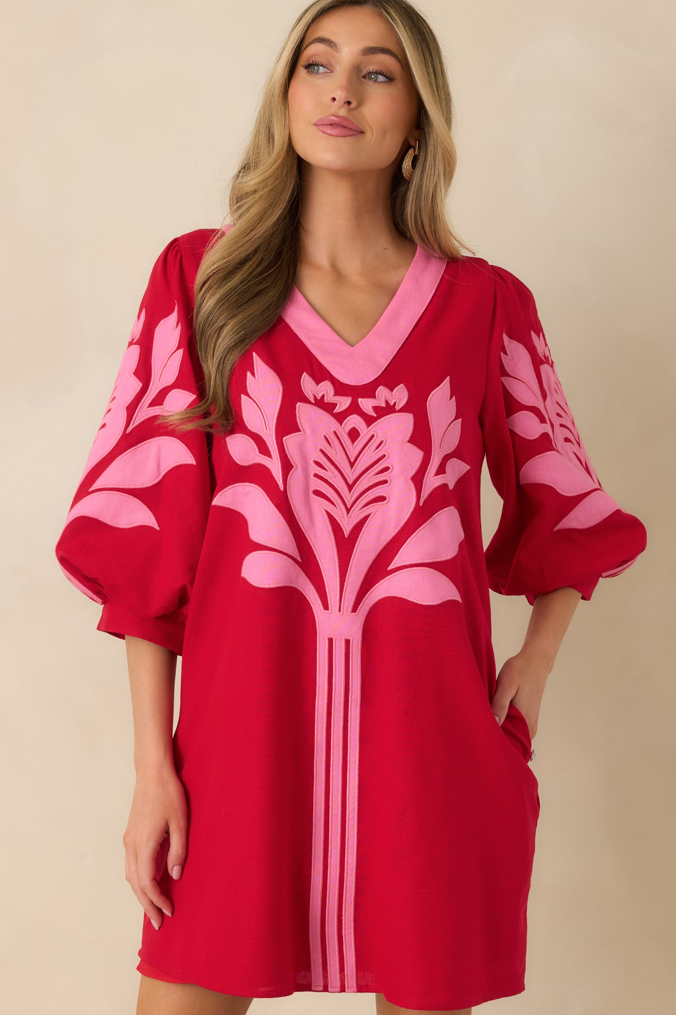 Front-focused cropped shot showing the lightweight woven fabric and relaxed fit of the red and pink mini dress.