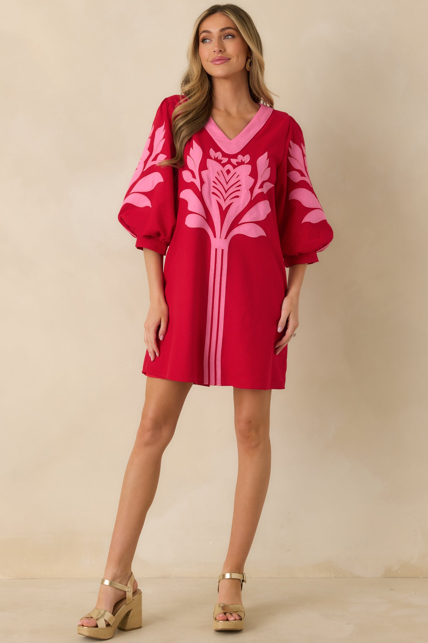 Red and pink mini dress with a relaxed fit, V-neckline, contrast trim, short puff sleeves, and gathered cuffs, falling to a straight hemline.