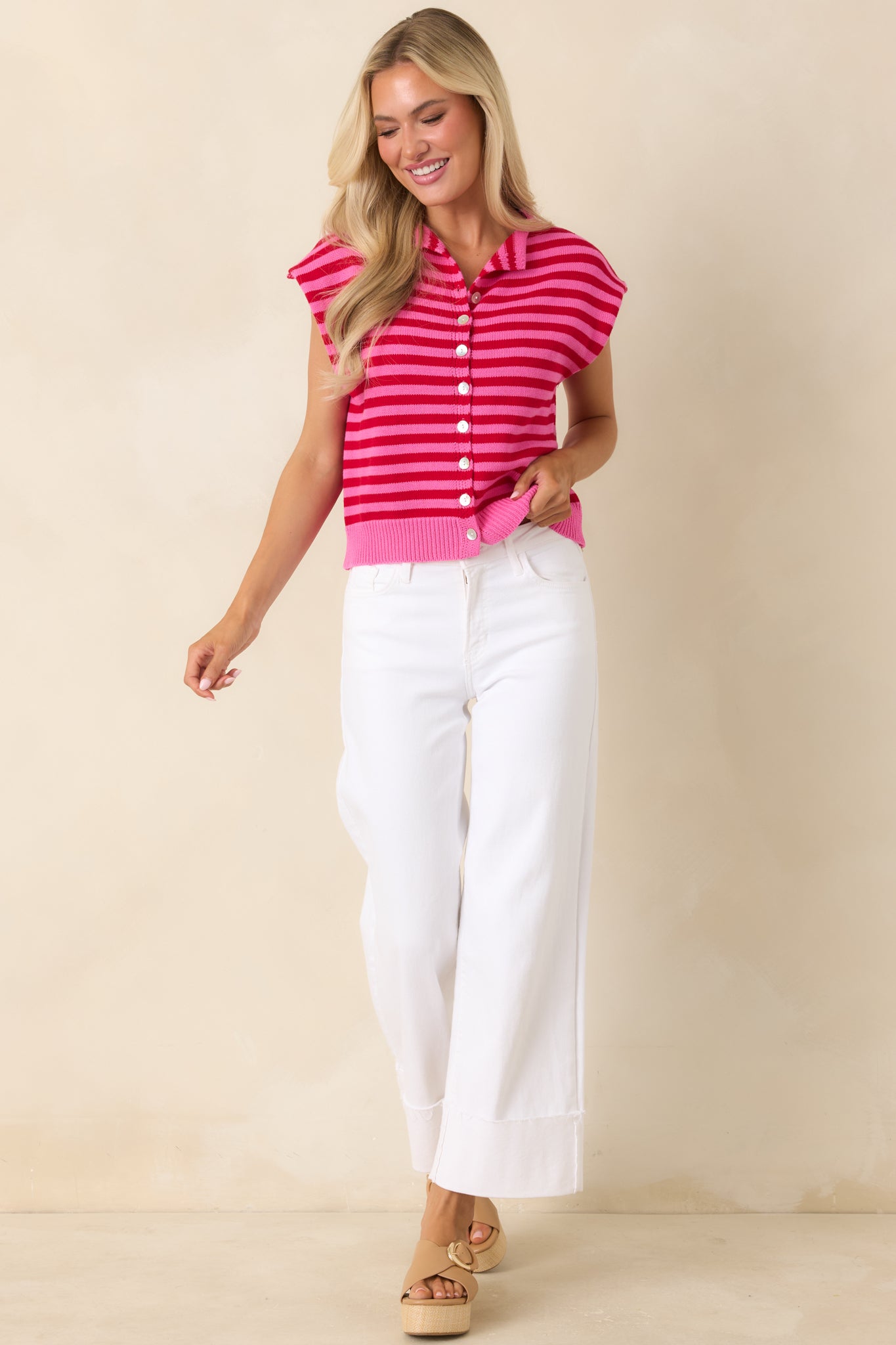 Red and pink striped knit top featuring a collared neckline, button-front design, and relaxed cap sleeves.