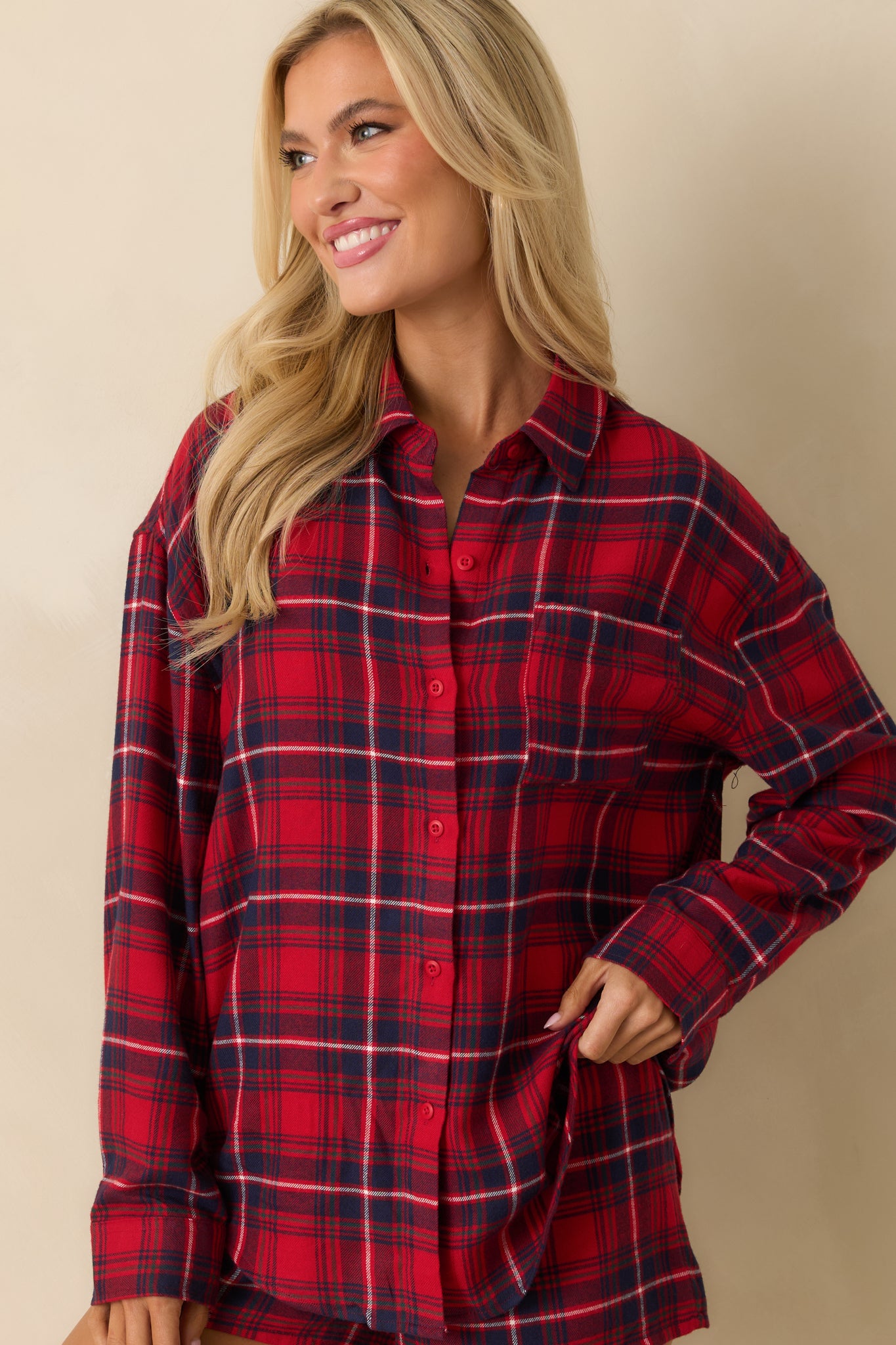 Detail of the front of red plaid button-up, emphasizing buttons, collar, and soft flannel weave.