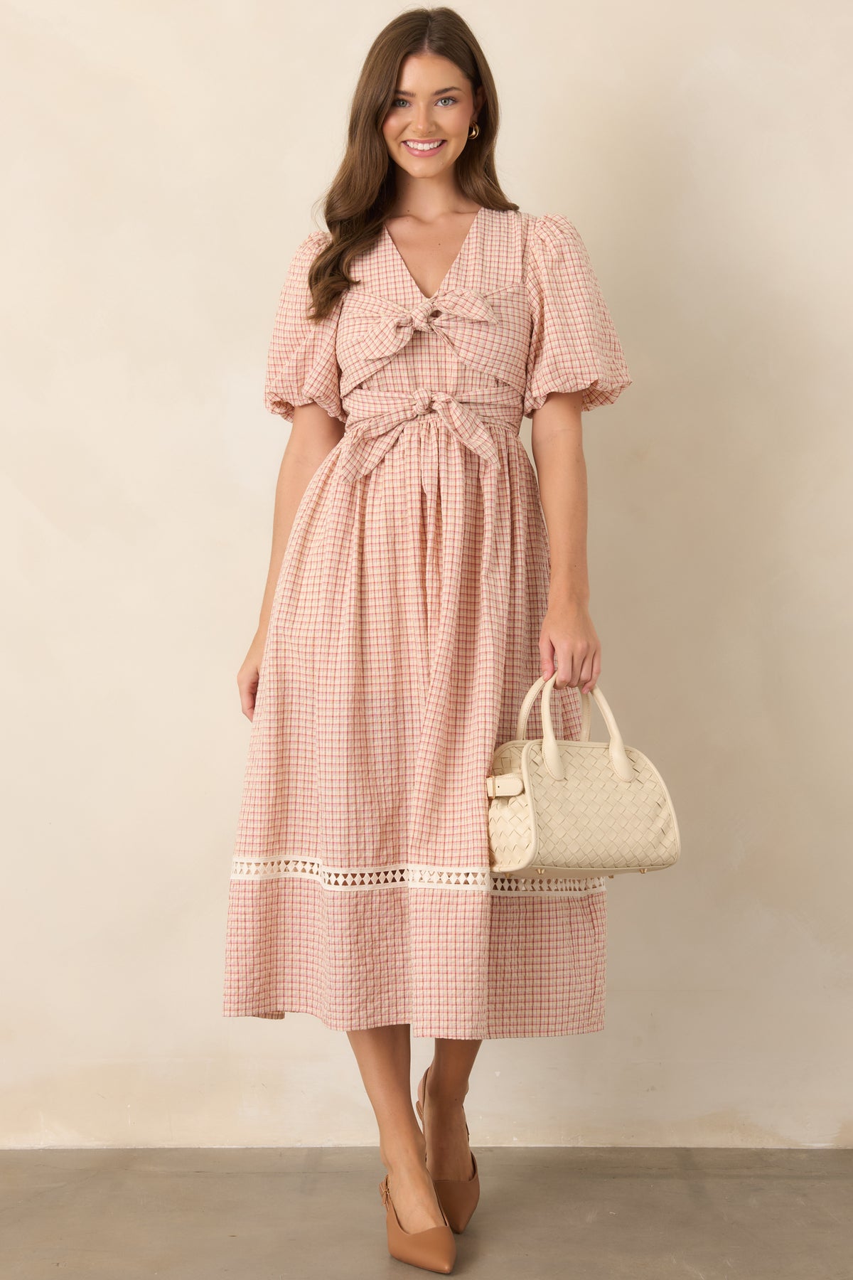 Red plaid midi dress with a fitted bodice, softly gathered elastic waist, puffed sleeves, and a voluminous skirt finished with crochet detailing.