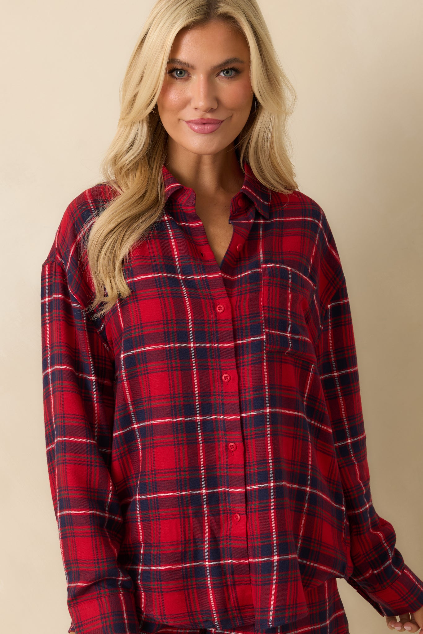 Close-up of red plaid flannel top, showcasing smooth texture, button closure, and casual relaxed fit.