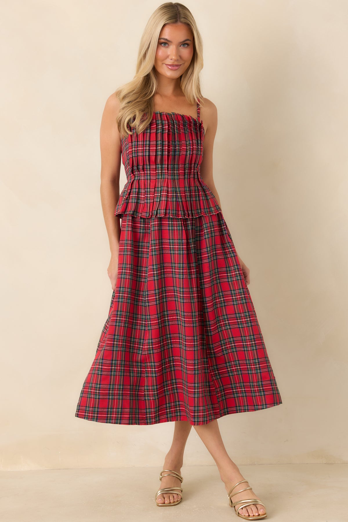Red plaid midi dress with thin adjustable straps and a flowing A-line skirt.