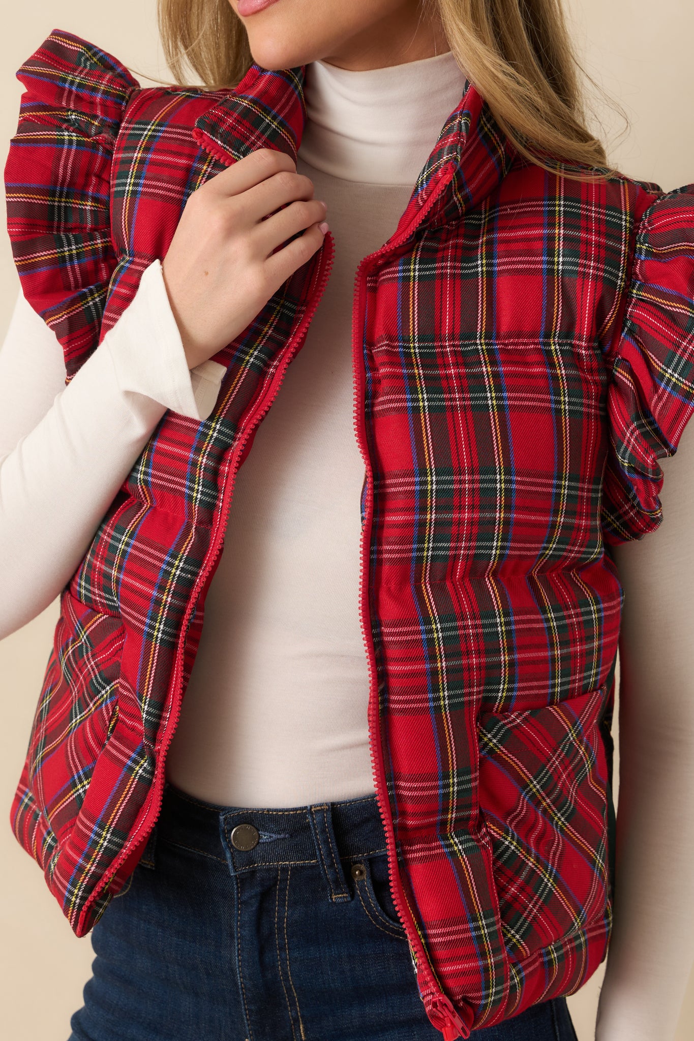 Red plaid puffer vest with a detailed look at the quilting and zipper hardware.