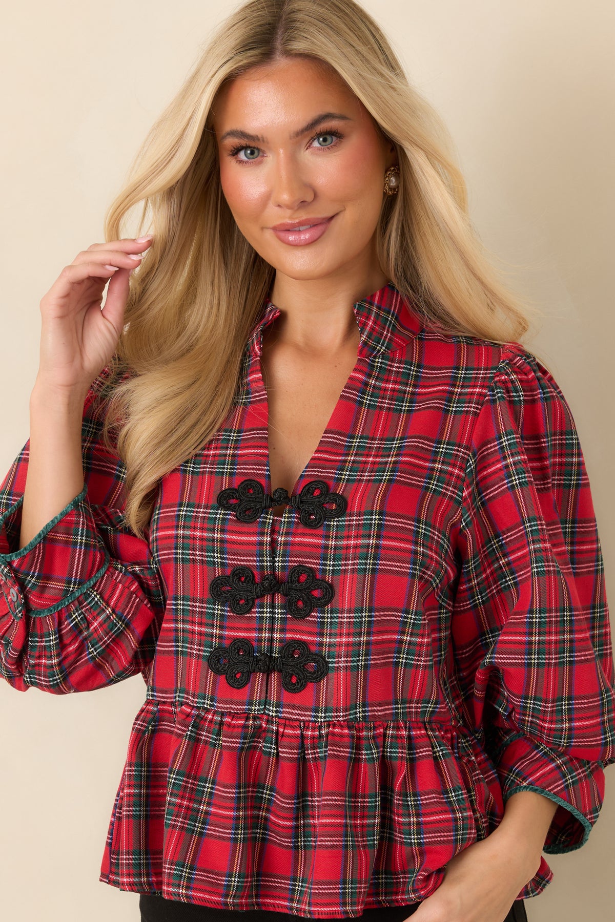 Red and green plaid top highlighting the stand collar, split neckline, and three black braided frog closures.