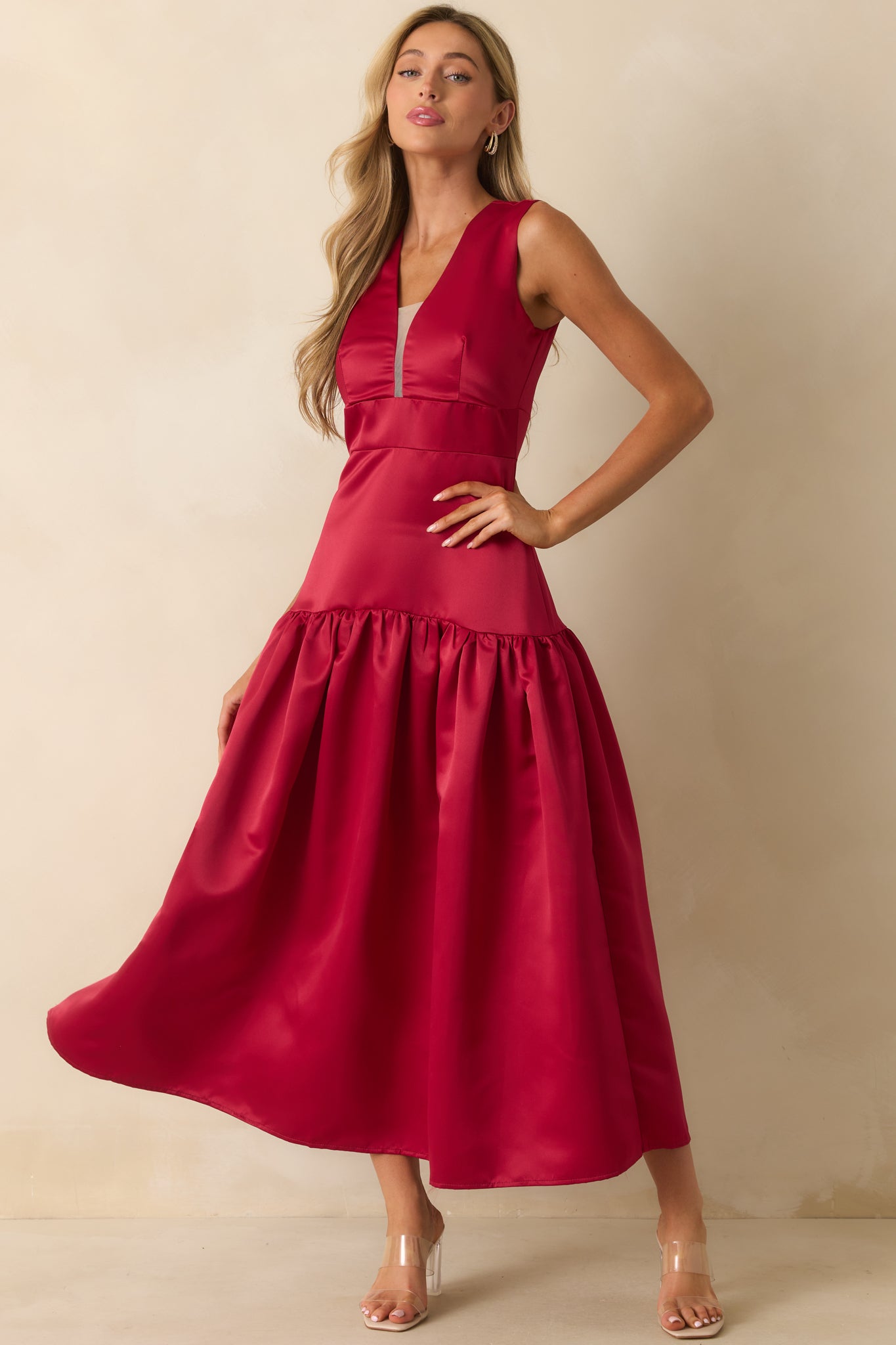 Flowing red maxi dress with a gathered skirt and sleek satin fabric.