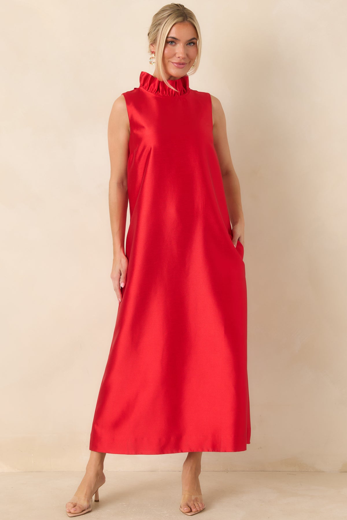 Red sleeveless maxi dress with a softly gathered ruffle collar and smooth fabric draping from the shoulders.