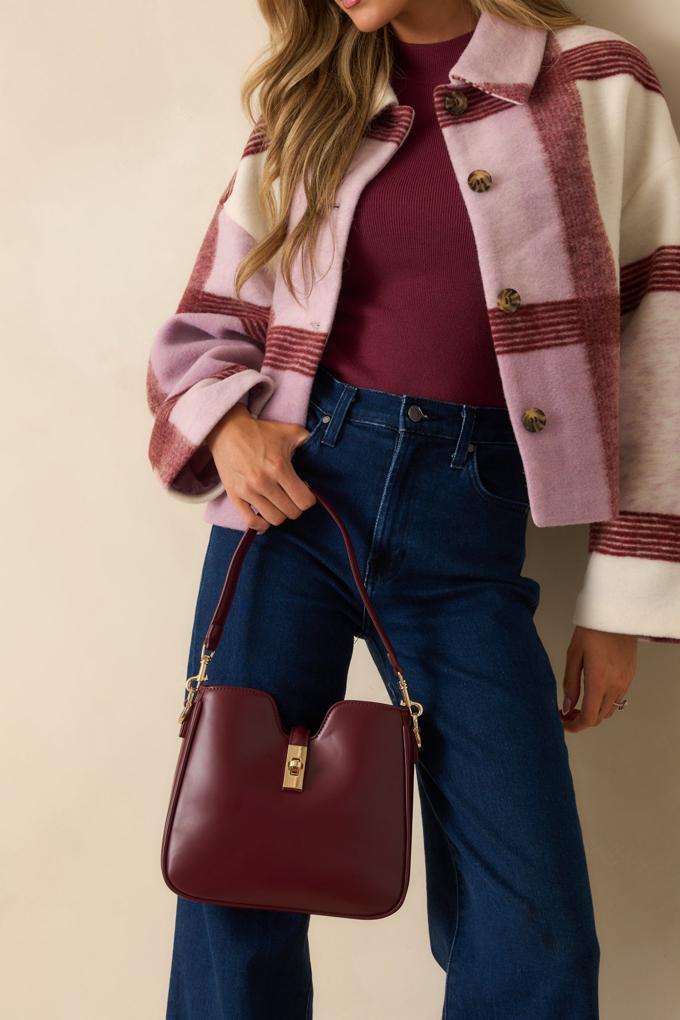 Wine red structured handbag displayed with its detachable strap, highlighting the smooth finish and elegant design.