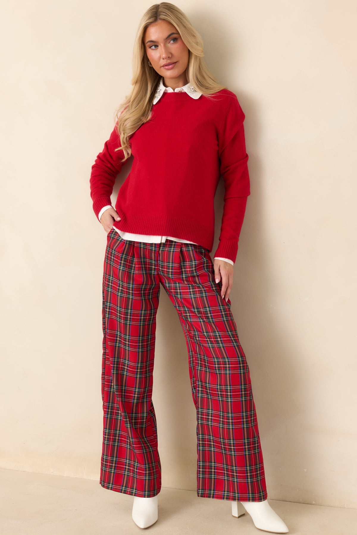 Red tartan plaid pants with a high waist, front pleats, and full-length wide legs