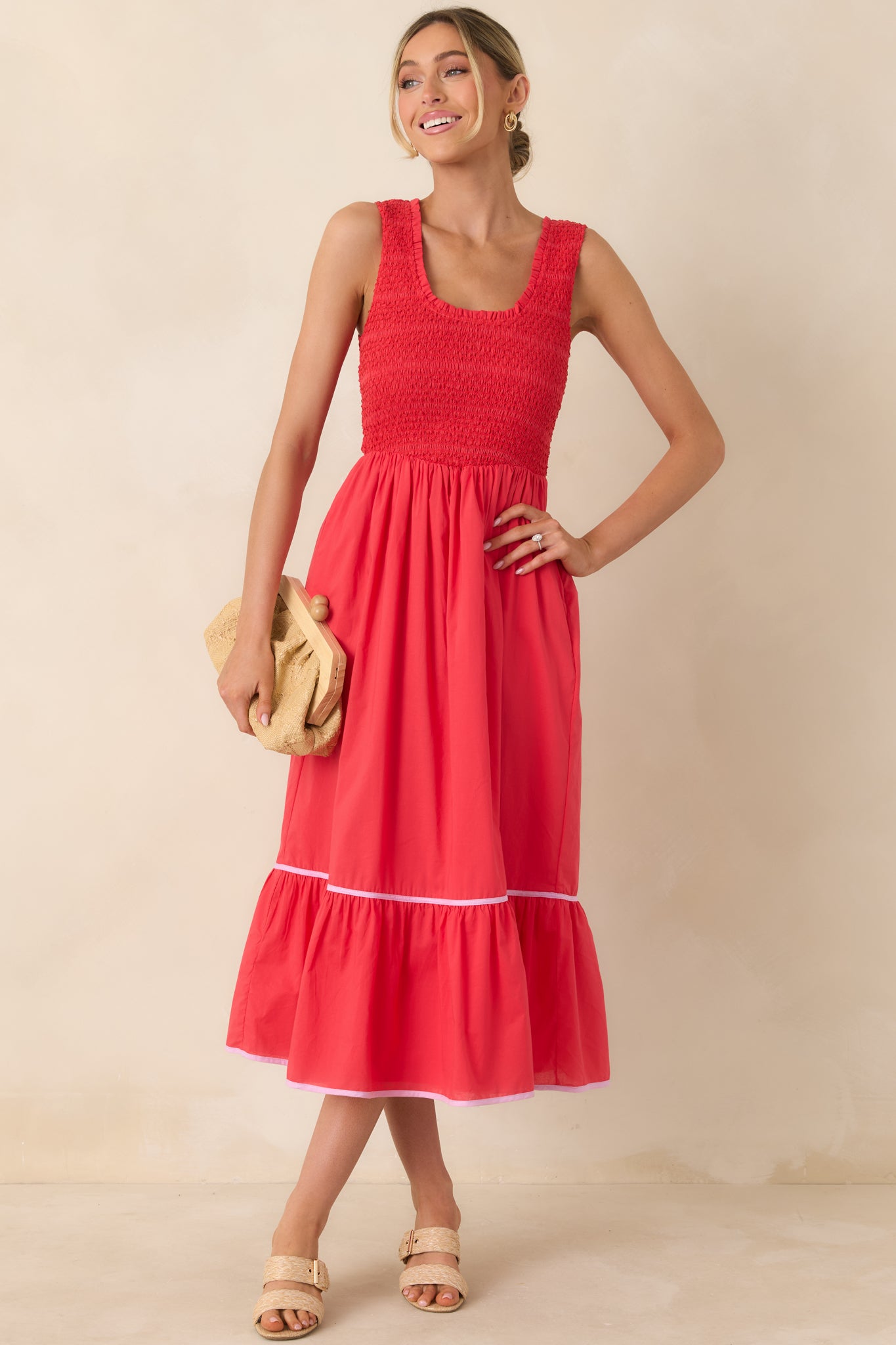 Red textured cotton midi dress with a sleeveless scoop neckline and smocked bodice for a flexible fit.