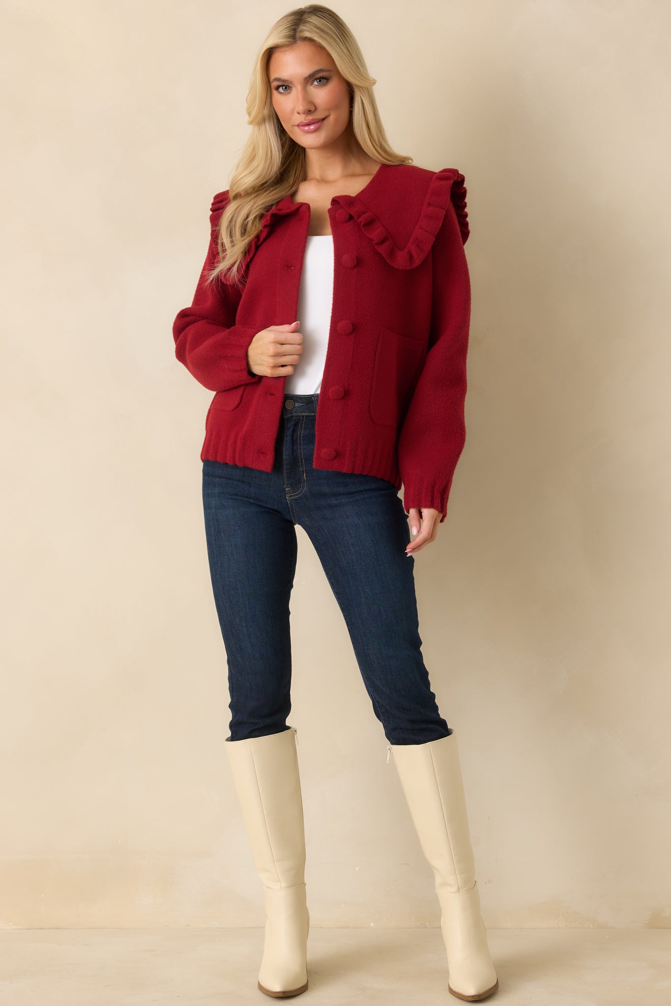 Red textured knit cardigan with oversize ruffle collar, patch pockets, and covered buttons.