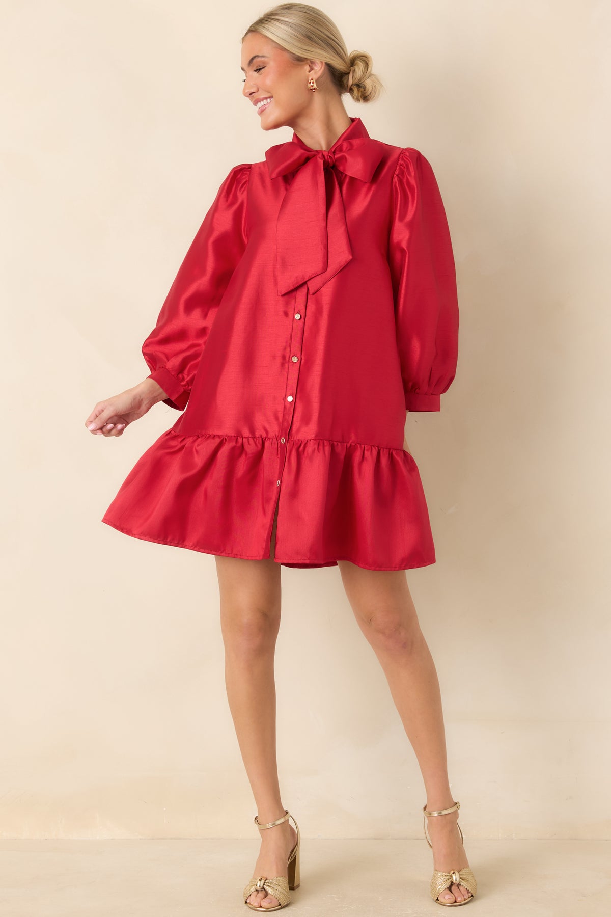 Shiny red mini dress with three-quarter puff sleeves, a gathered waistline, and a ruffled skirt hem.