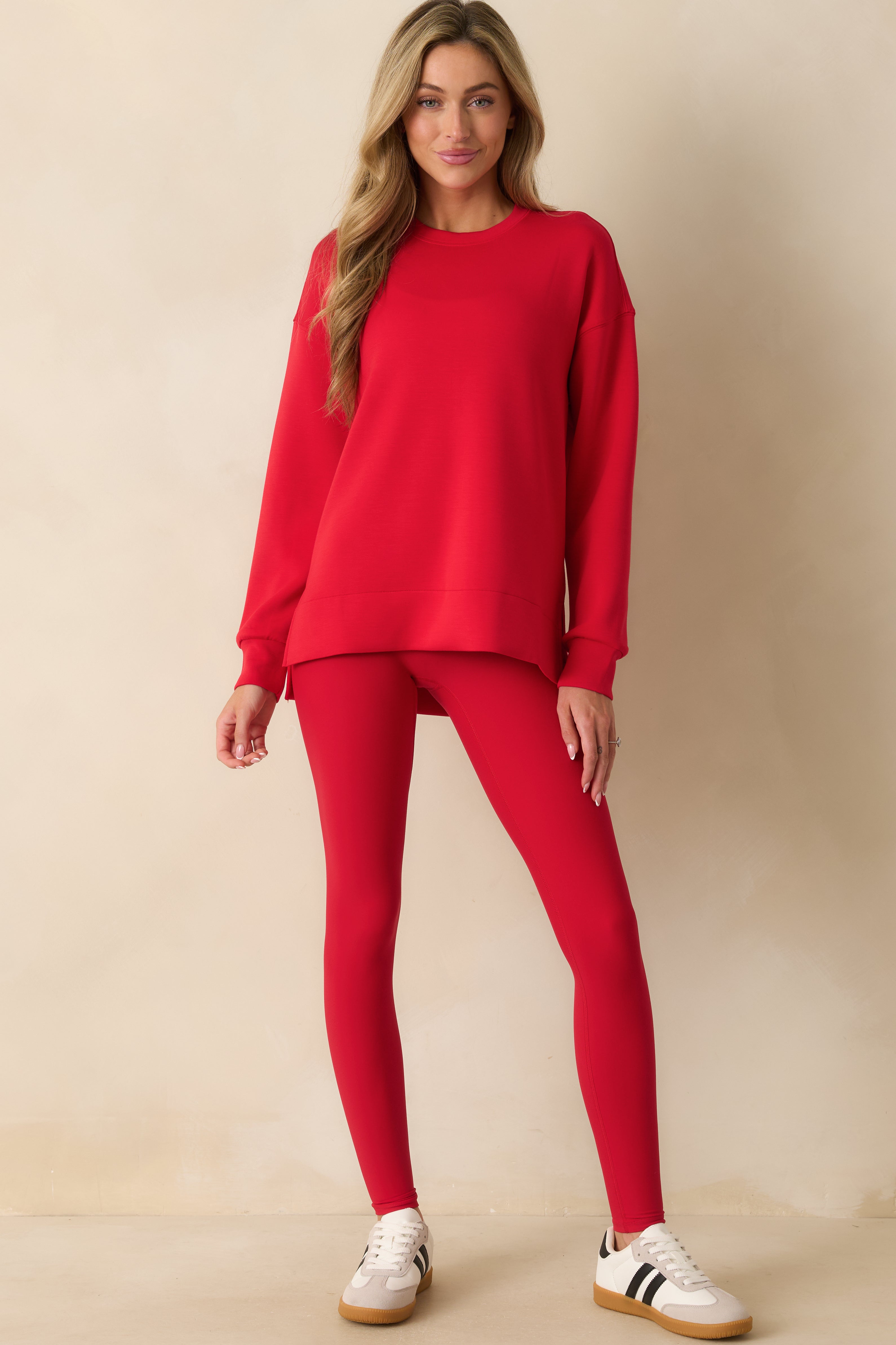 Crewneck red tunic emphasizing its longer length and fluid, lightweight fabric.