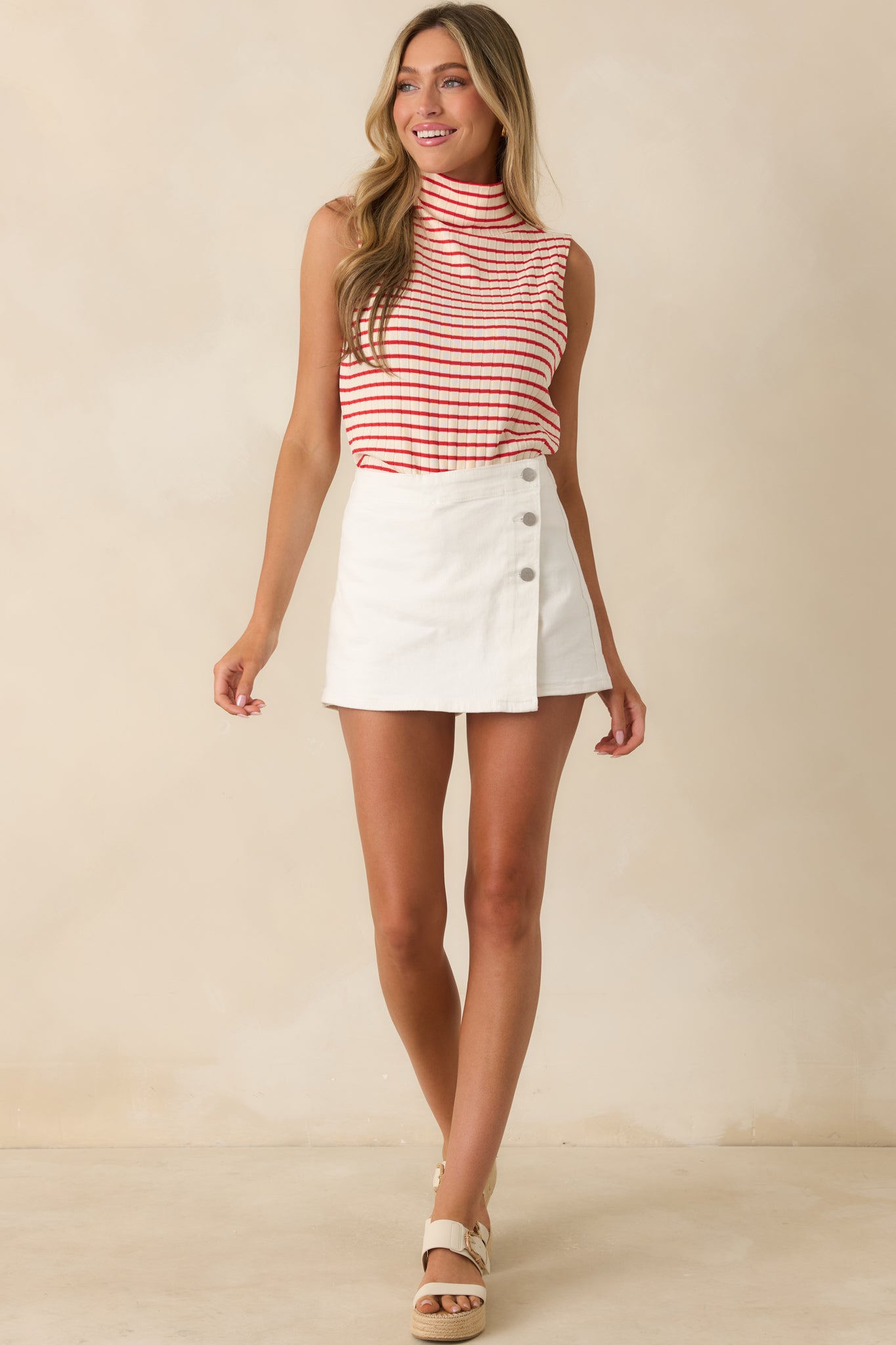 Red and white striped ribbed knit top featuring a sleeveless silhouette, mockneck neckline, and fitted design.
