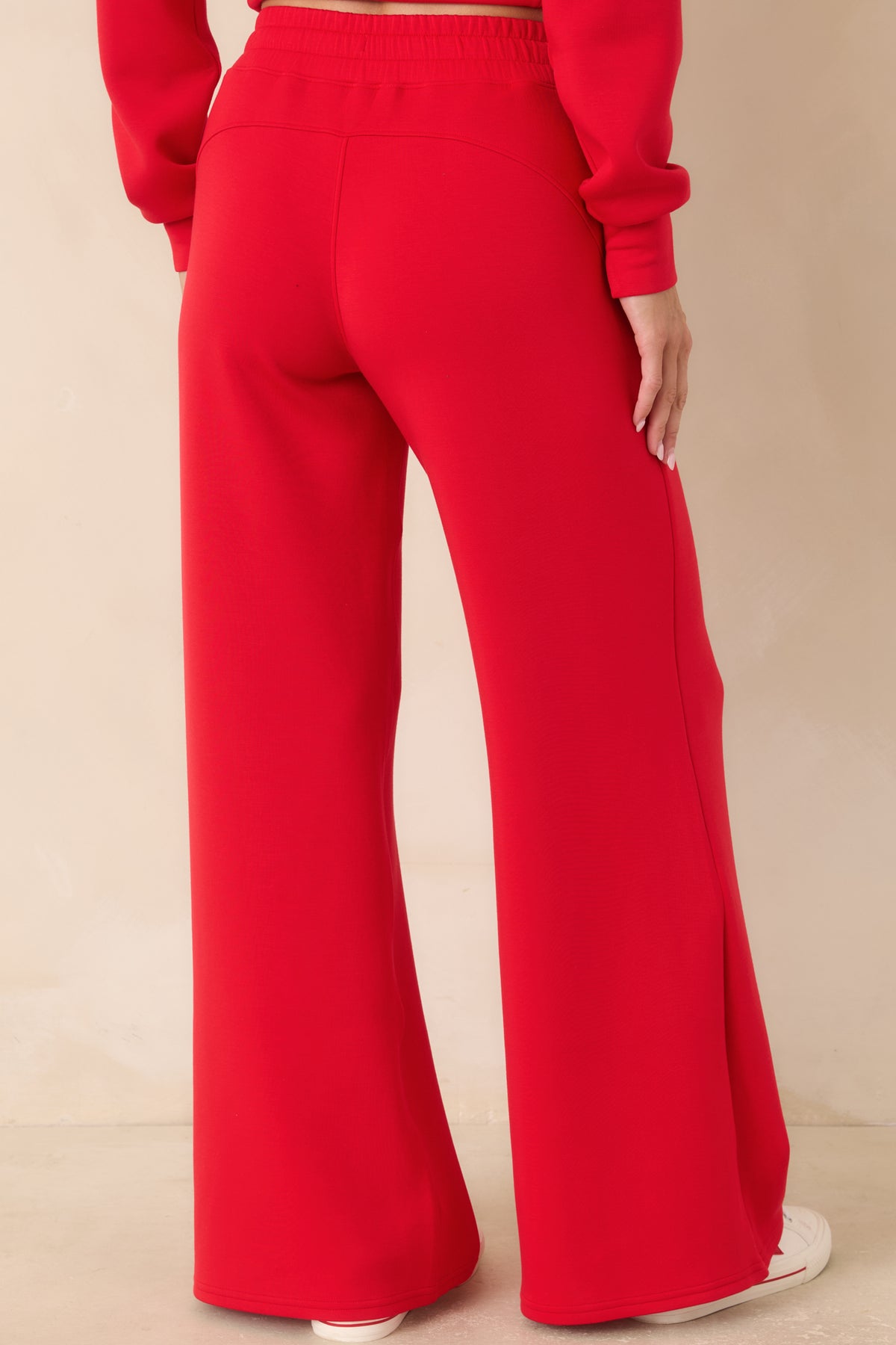 Rear view of the vibrant red wide-leg pants featuring a relaxed silhouette, smooth finish, and clean back construction.