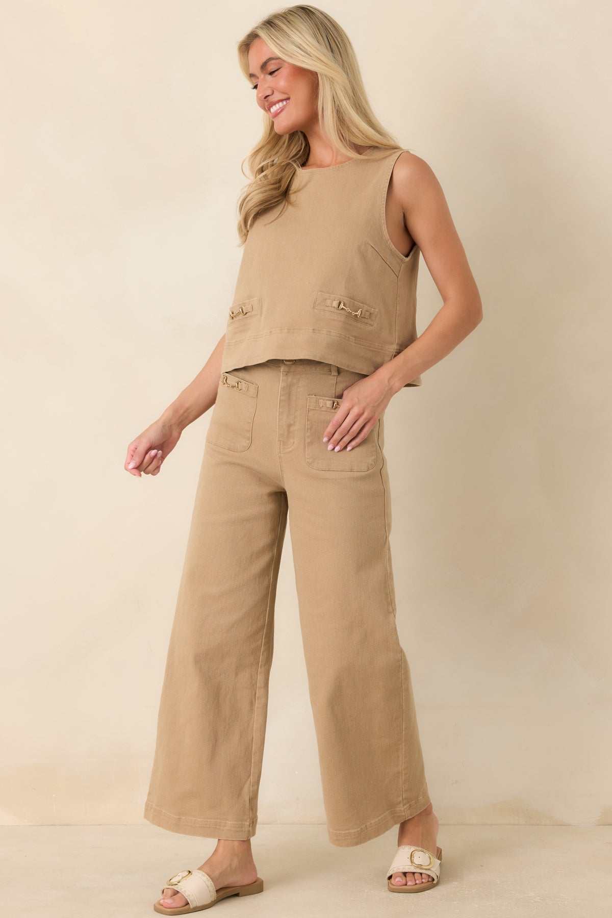 Relaxed A-line denim top featuring a sleeveless silhouette, round neckline, and refined gold-tone hardware accents.