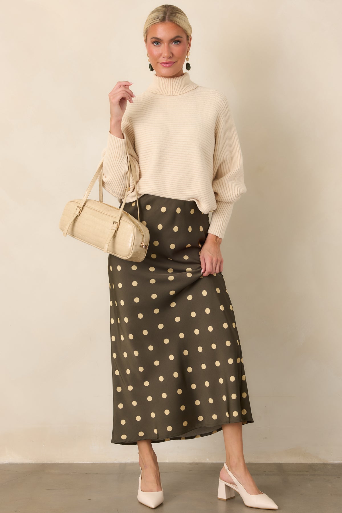 Relaxed rib knit sweater showcasing voluminous batwing sleeves, a structured turtleneck, and cropped hemline.